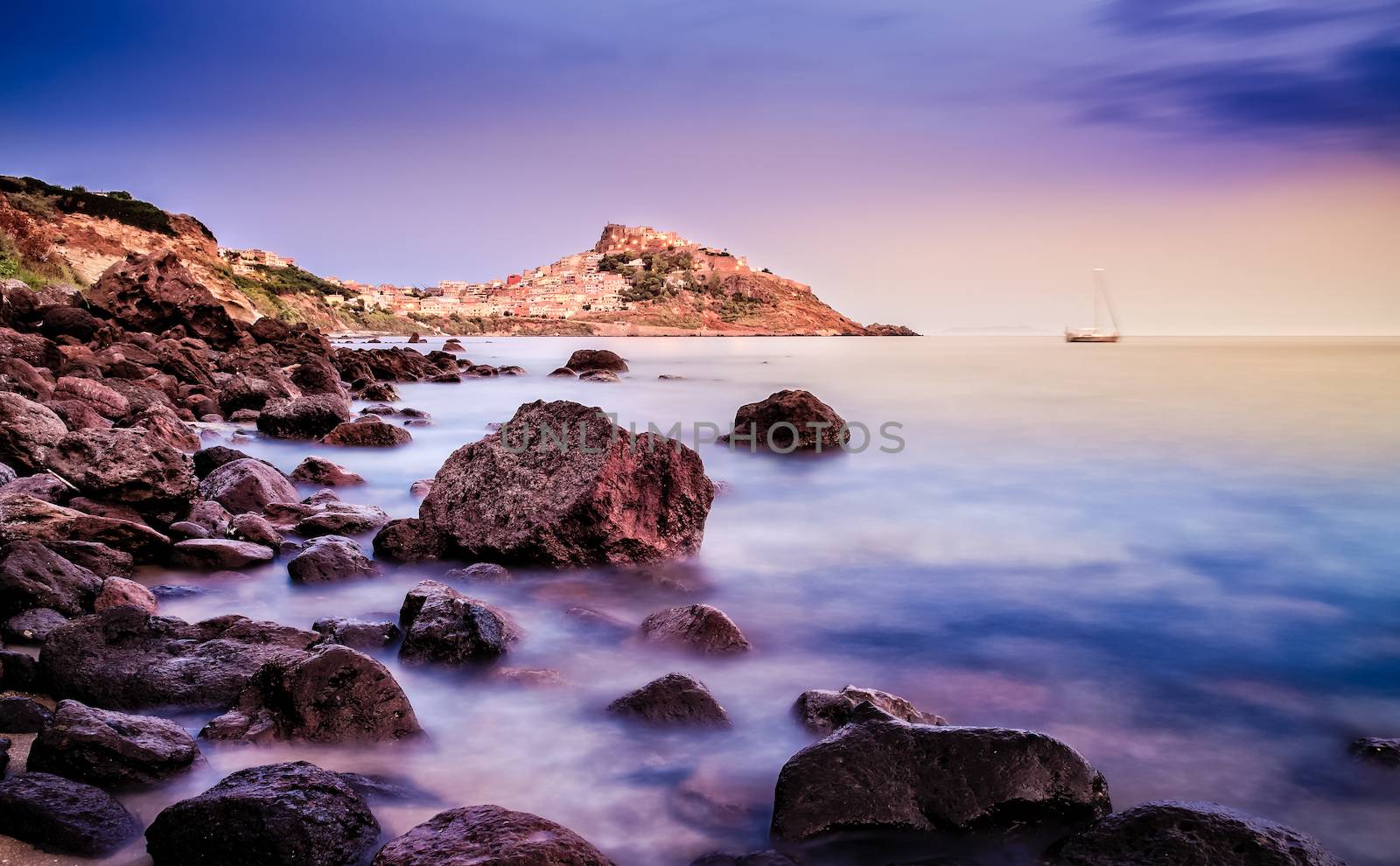 Ocean coastline with village in the background at sunrise by martinm303