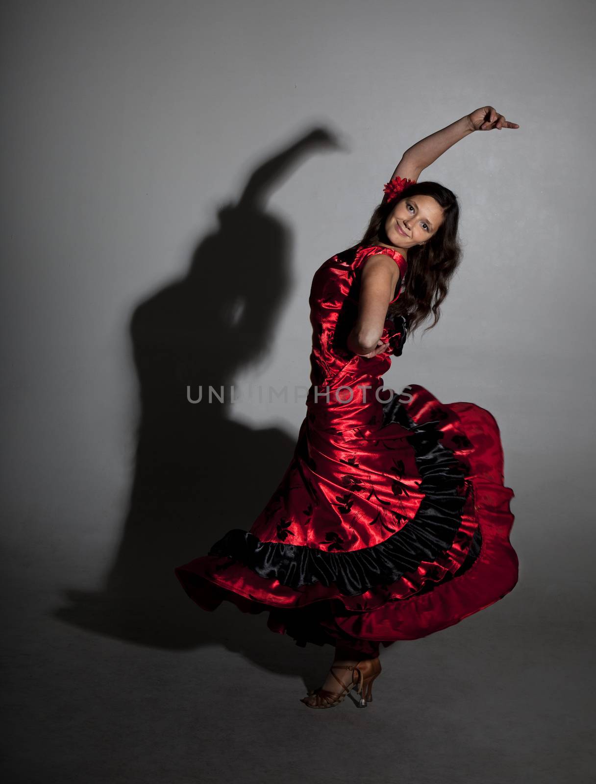 Young woman dancing flamenco, studio shot, gray background