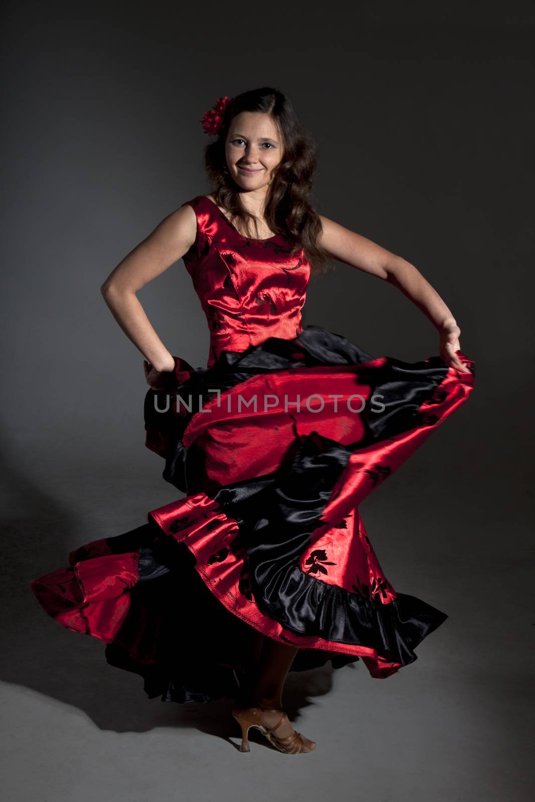 Young woman dancing flamenco, studio shot, gray background