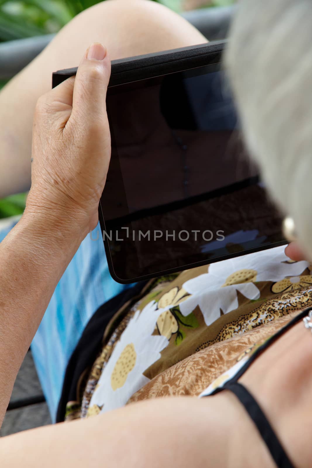 Senior woman using tablet at home