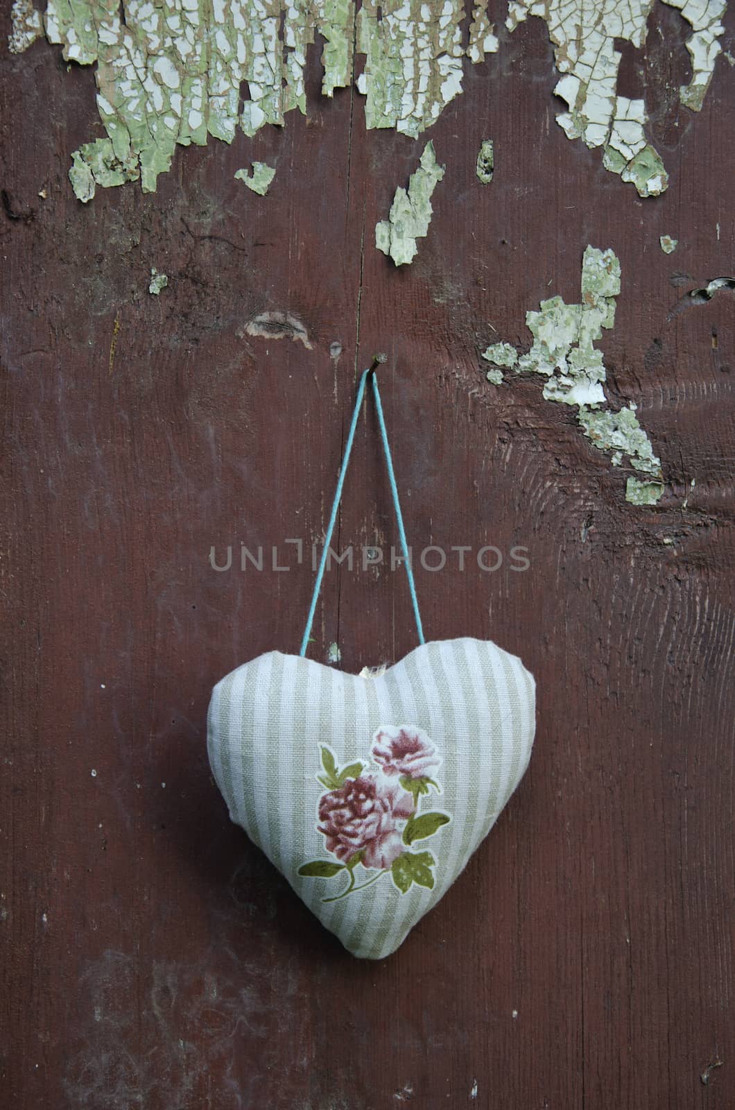 decorative cloth heart textile hanging on old cracked wooden  wall