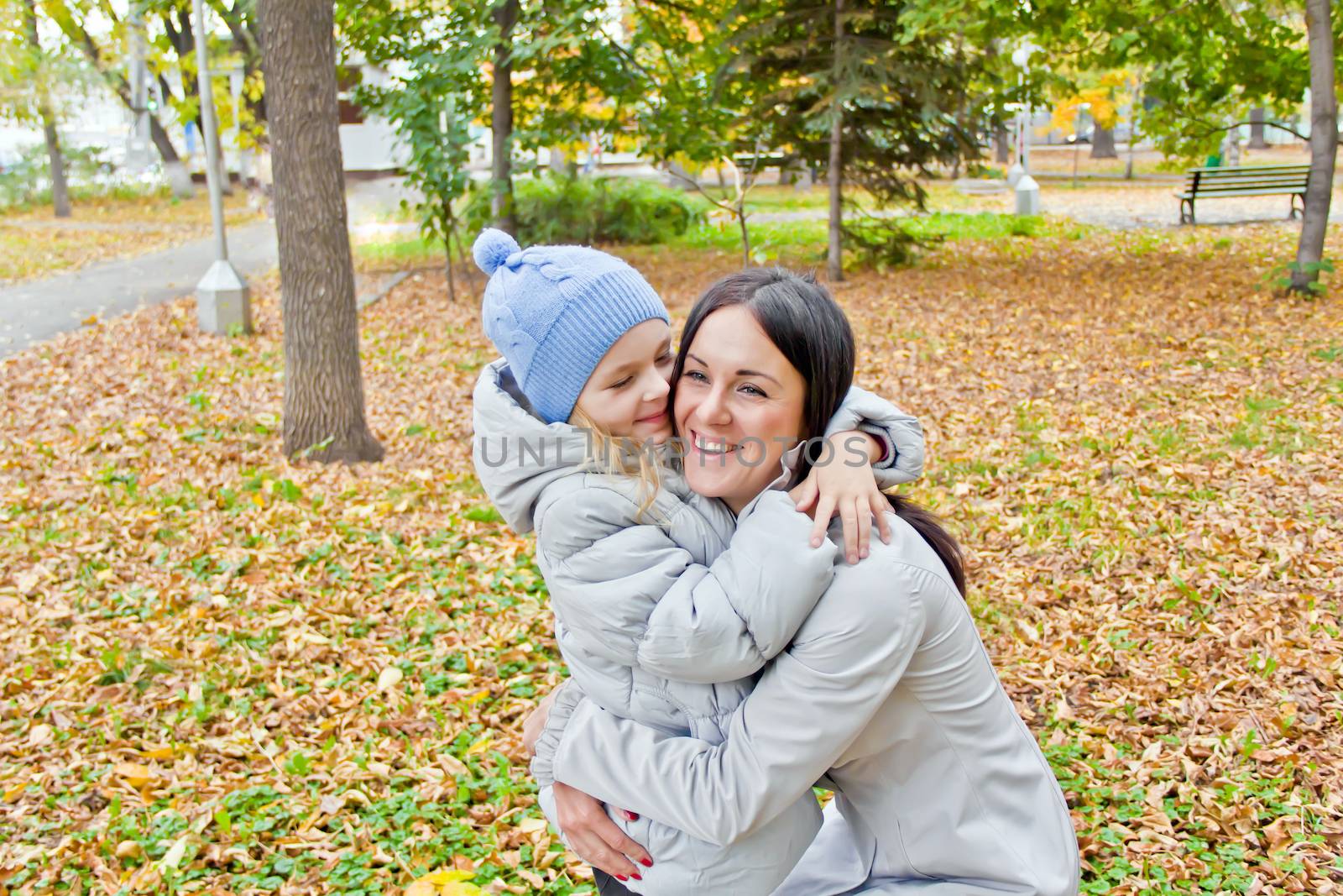 Photo of smiling mother and daughter in autumn