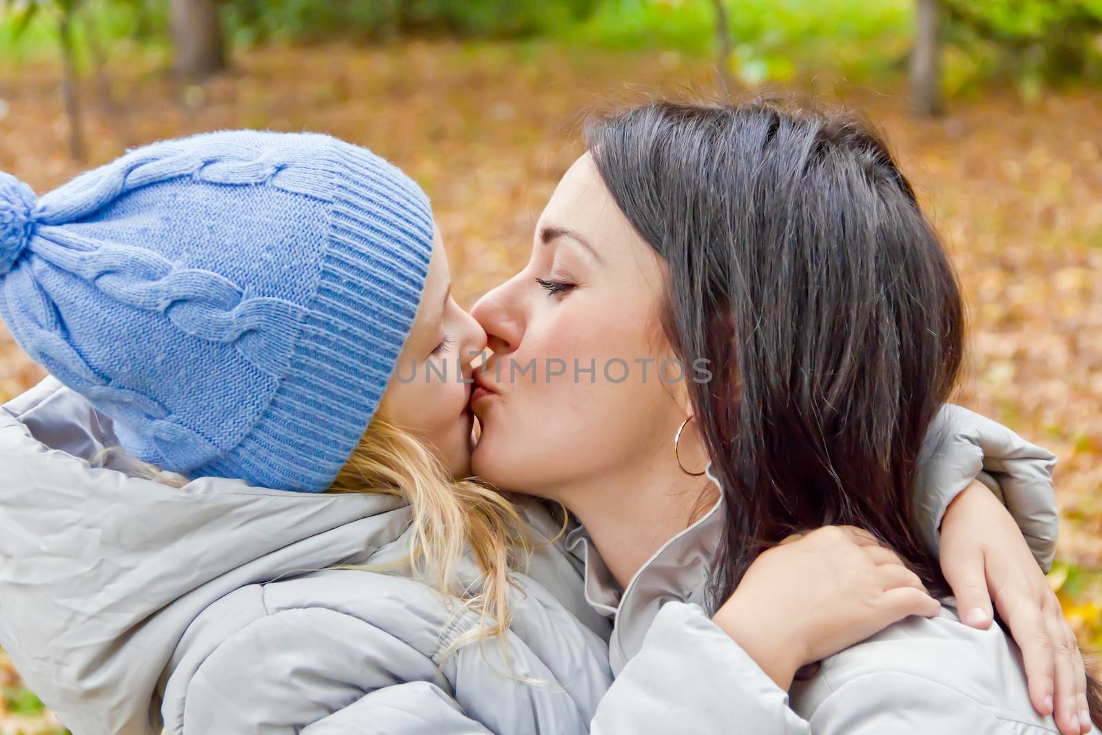 Photo of kissing mother and daughter in autumn