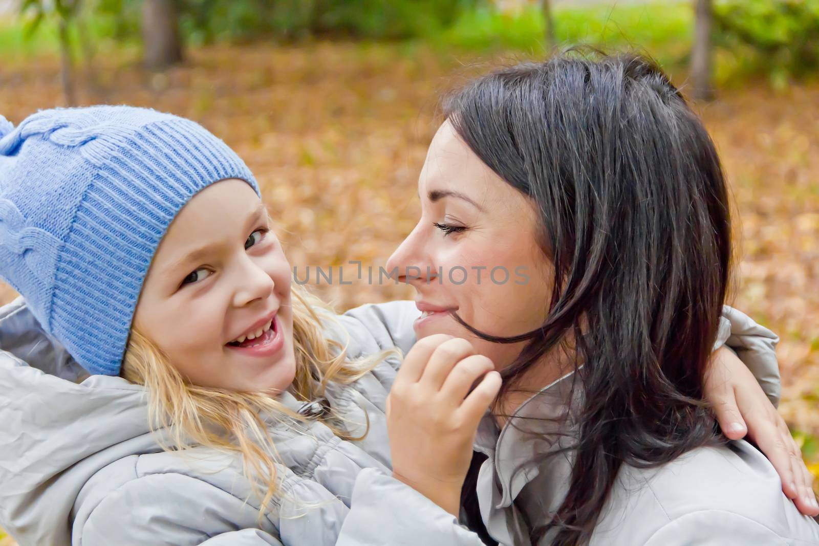 Photo of smiling mother and daughter in autumn