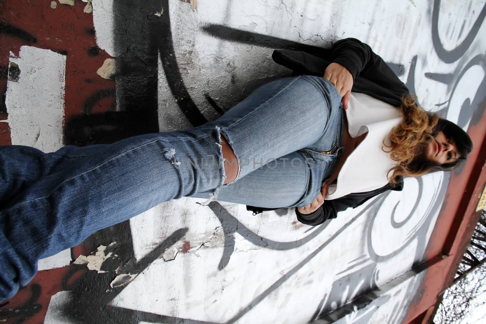 A young woman leaning on a wall.