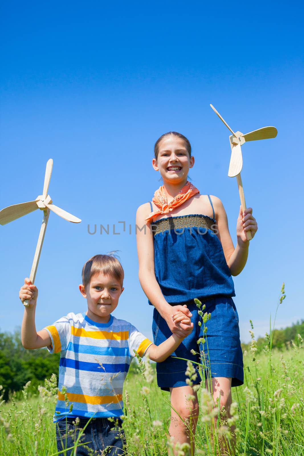 Kids in summer day holds windmill by maxoliki