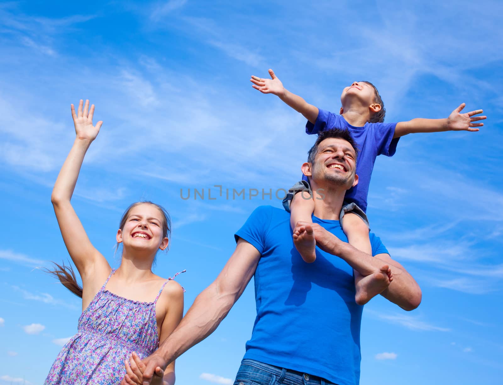 Happy father with kids outdoors against sky by maxoliki
