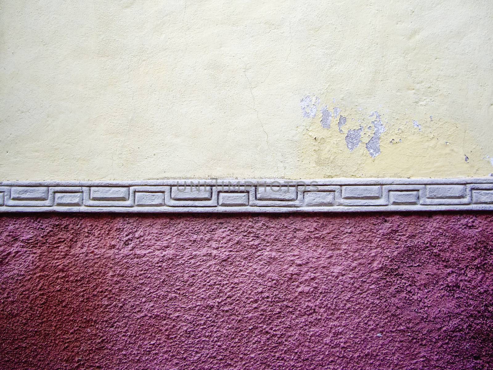 Red and yellow adobe wall with tile in Mexico