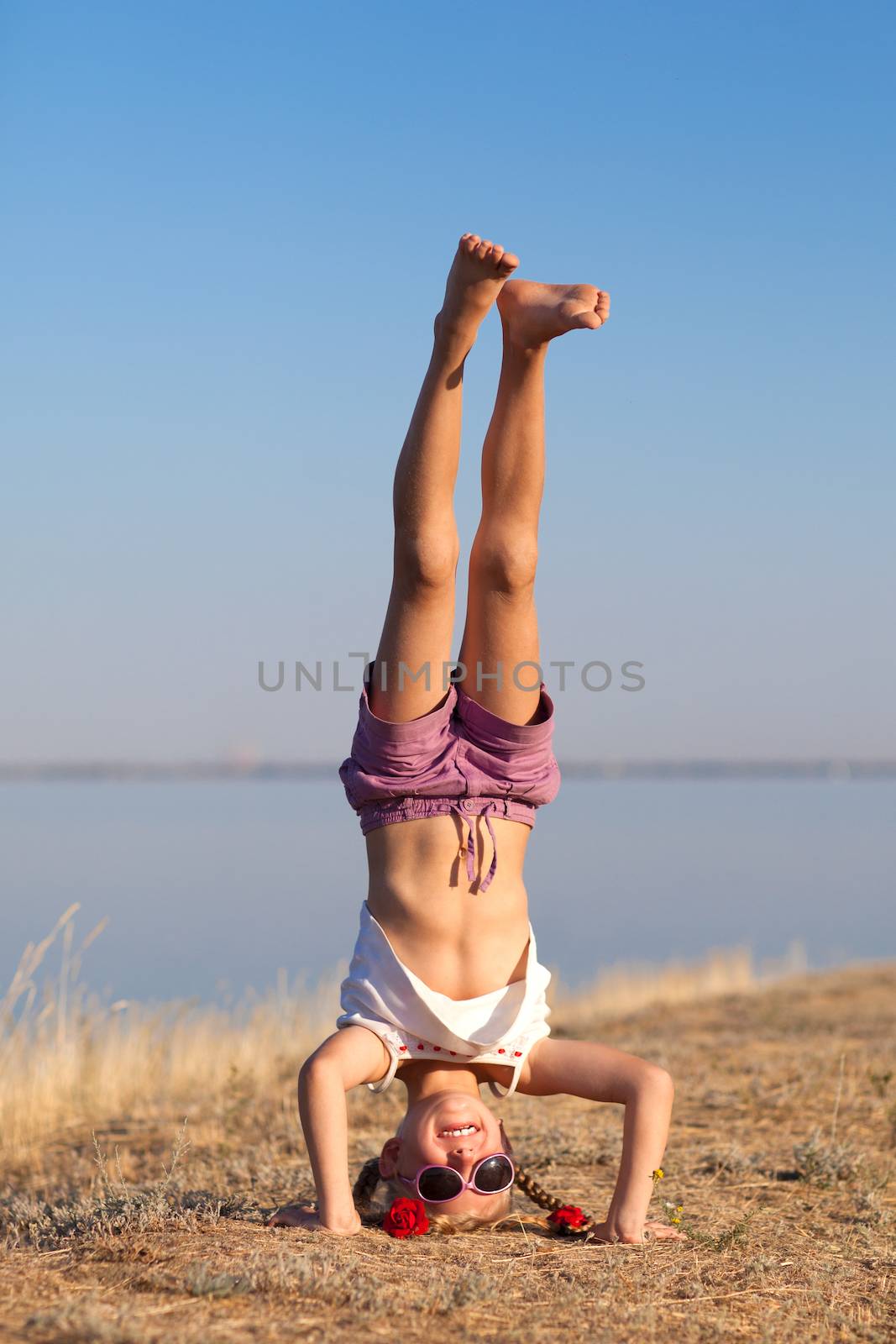 girl doing head stand on the beach