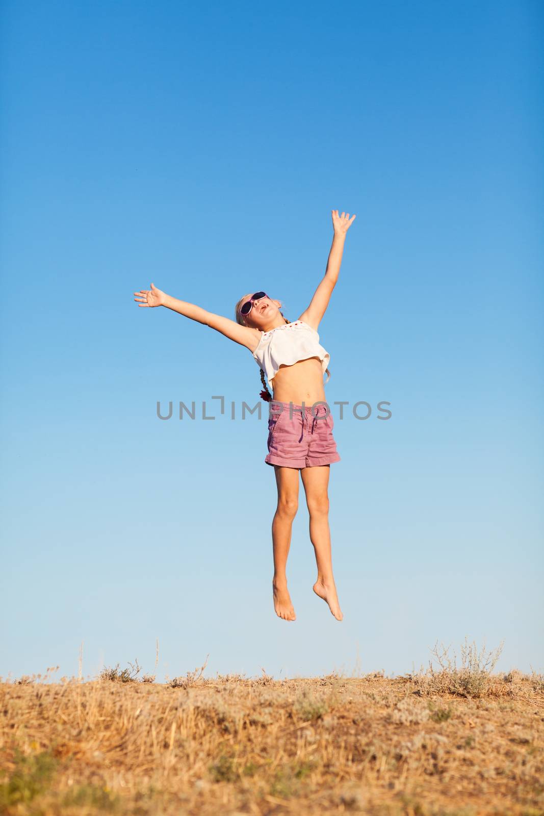 happy small girl jumping outdoors