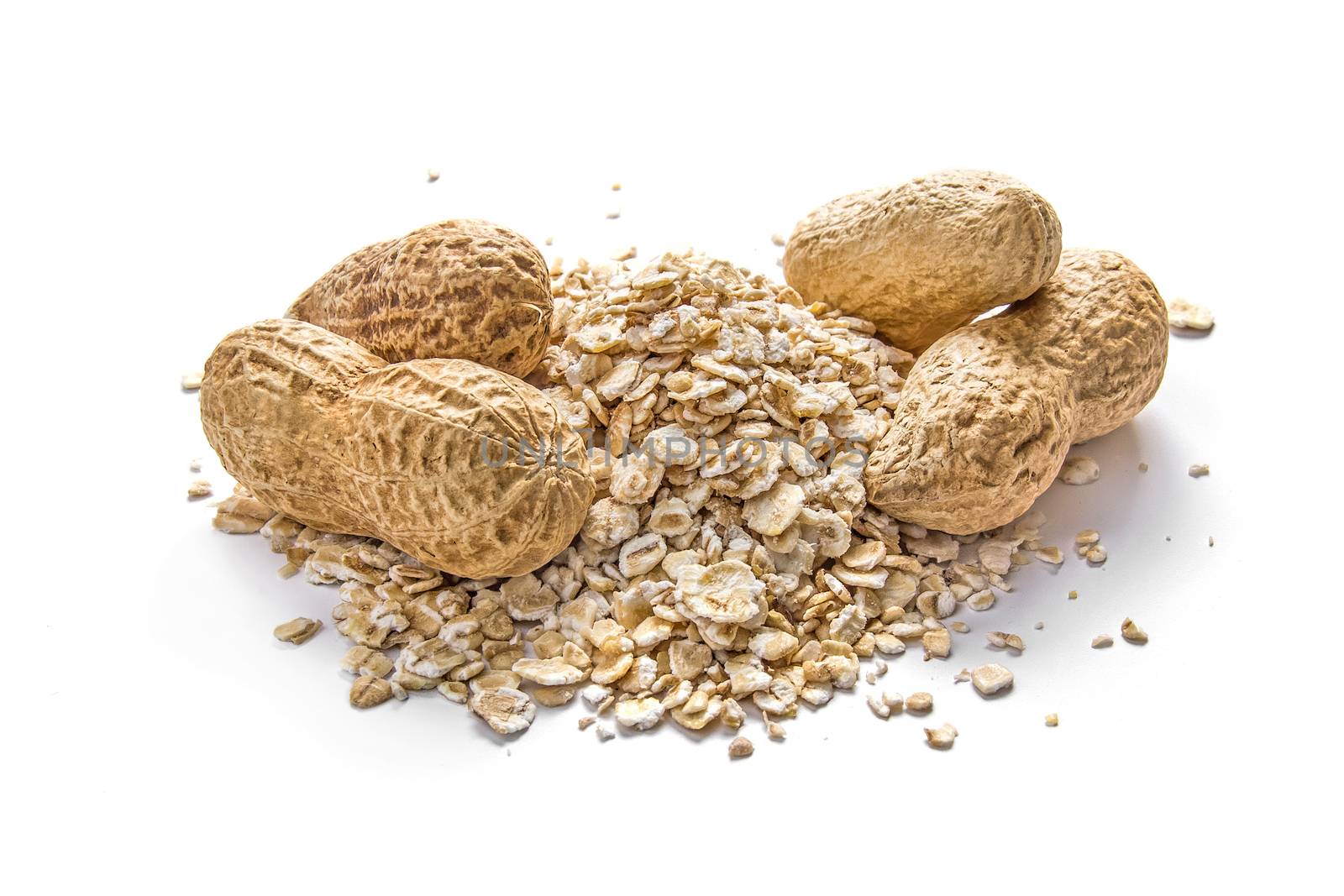 Peanuts and oatmeal grains on white background