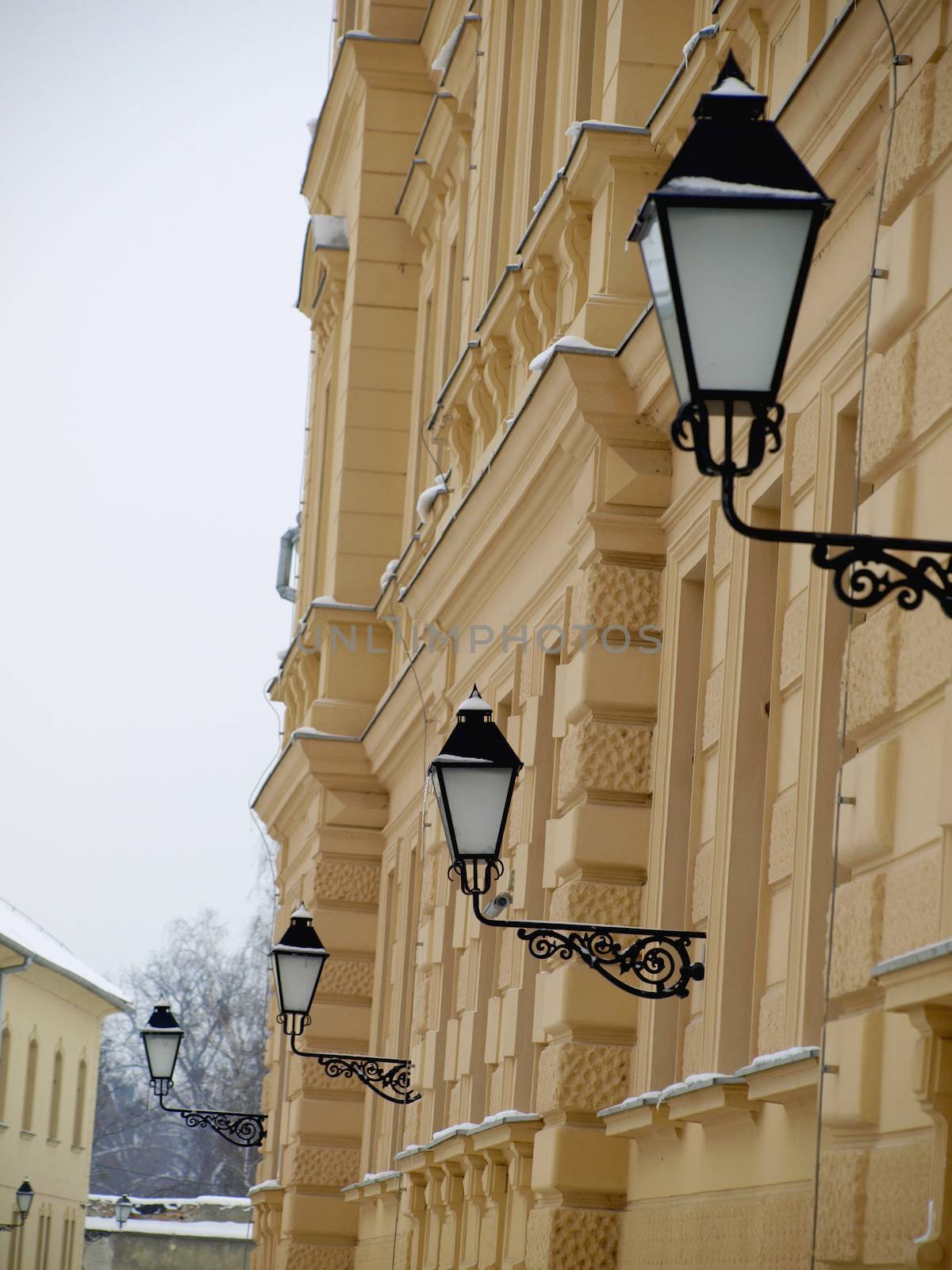 yellow building with windows and street lamp    