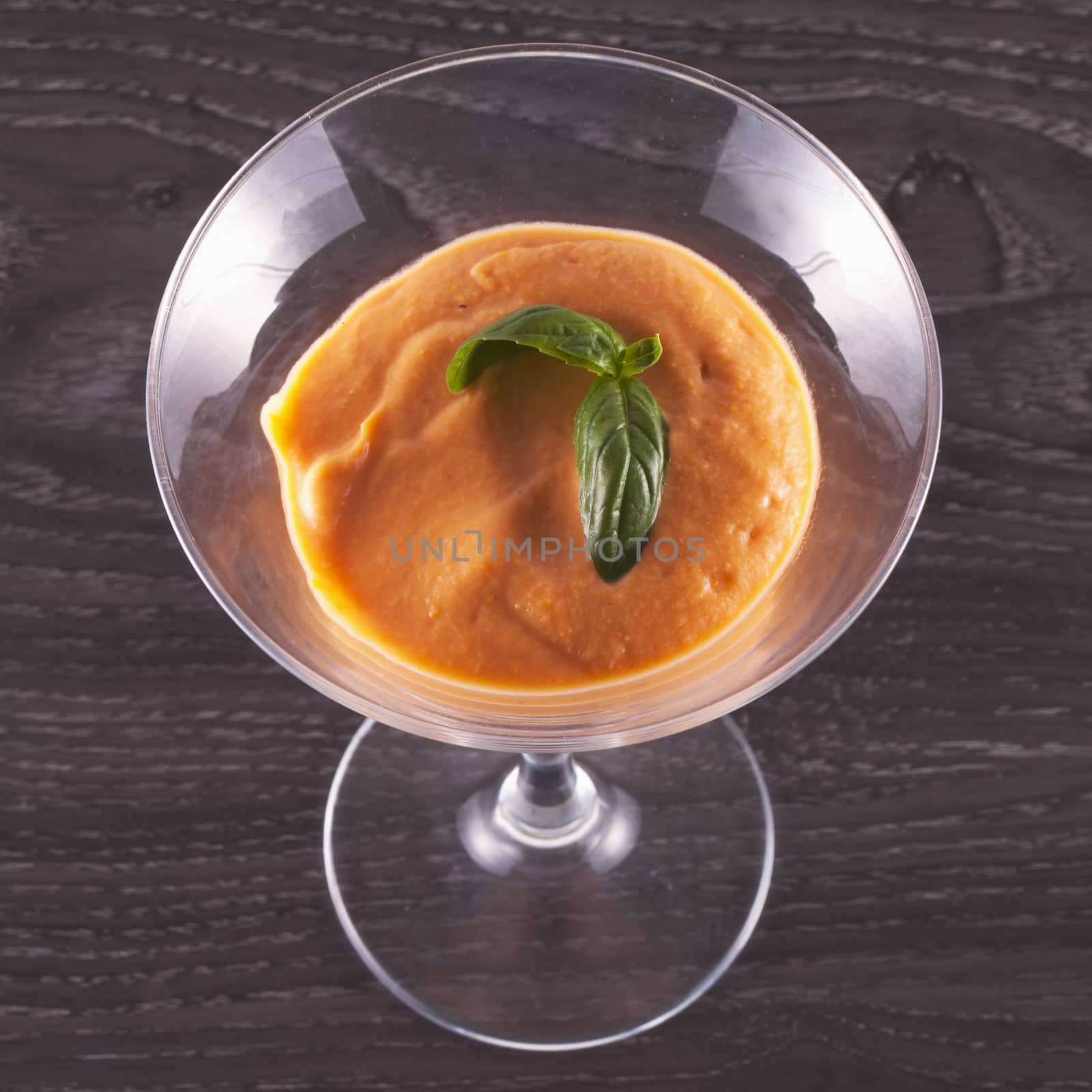 Gazpacho in a glass cup over wooden table