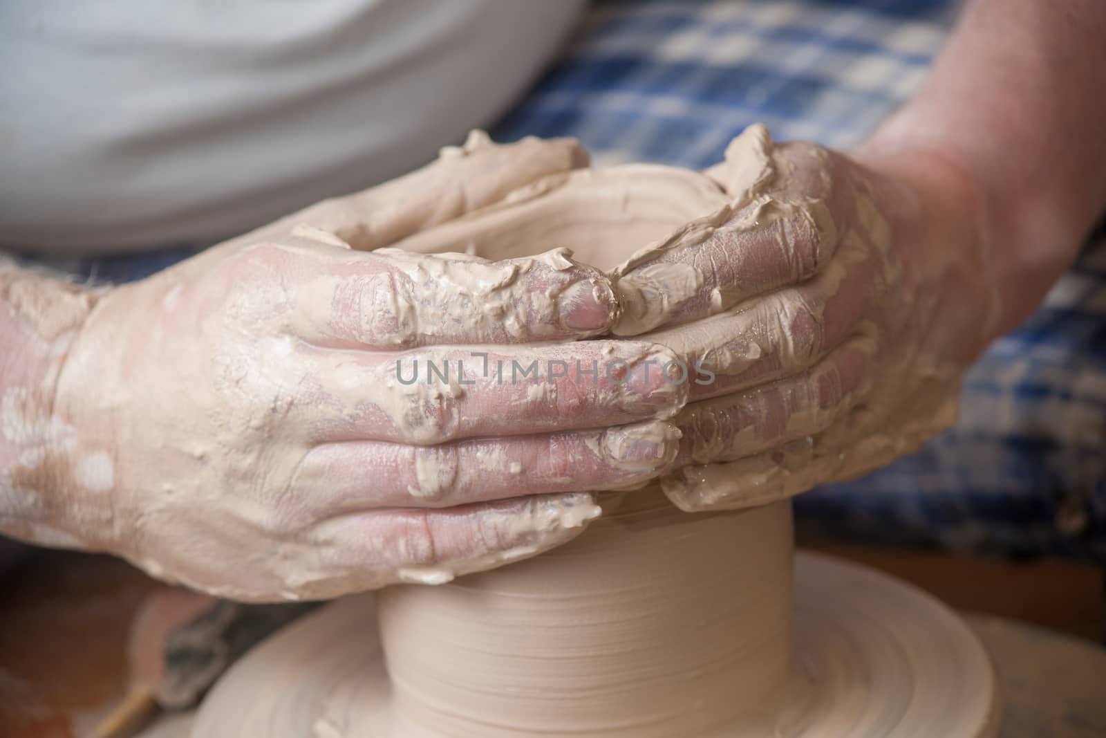 Hands of a potter, creating an earthen jar on the circle