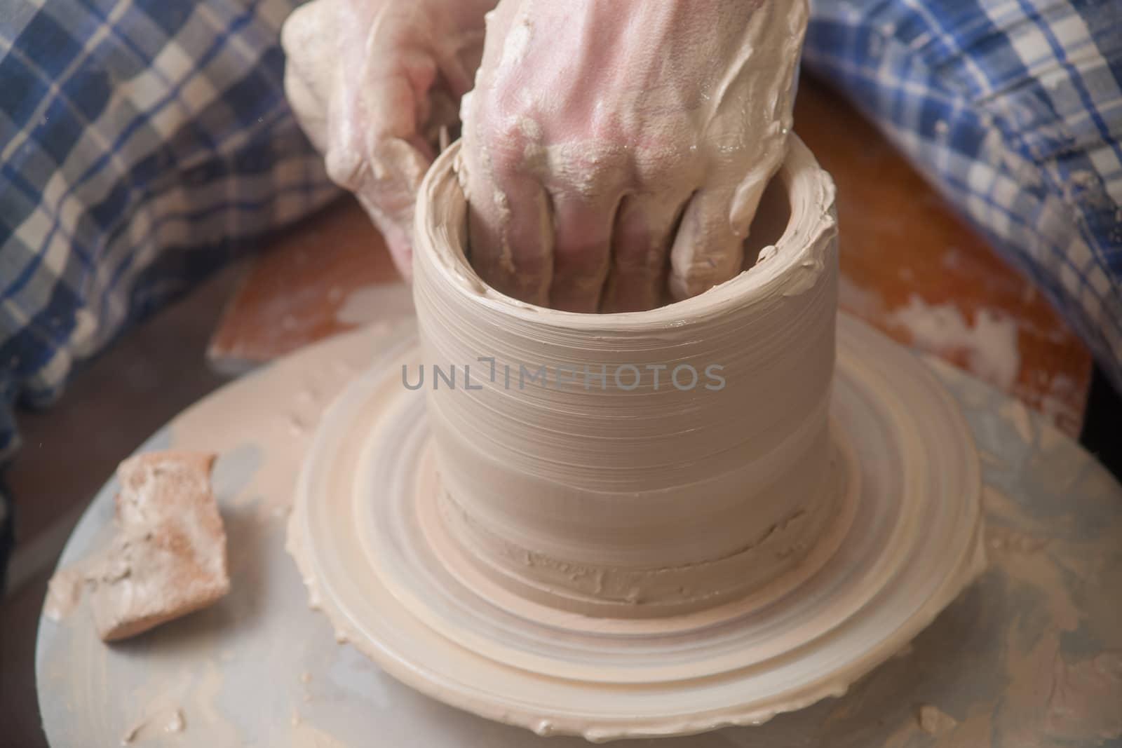 Hands of a potter, creating an earthen jar on the circle