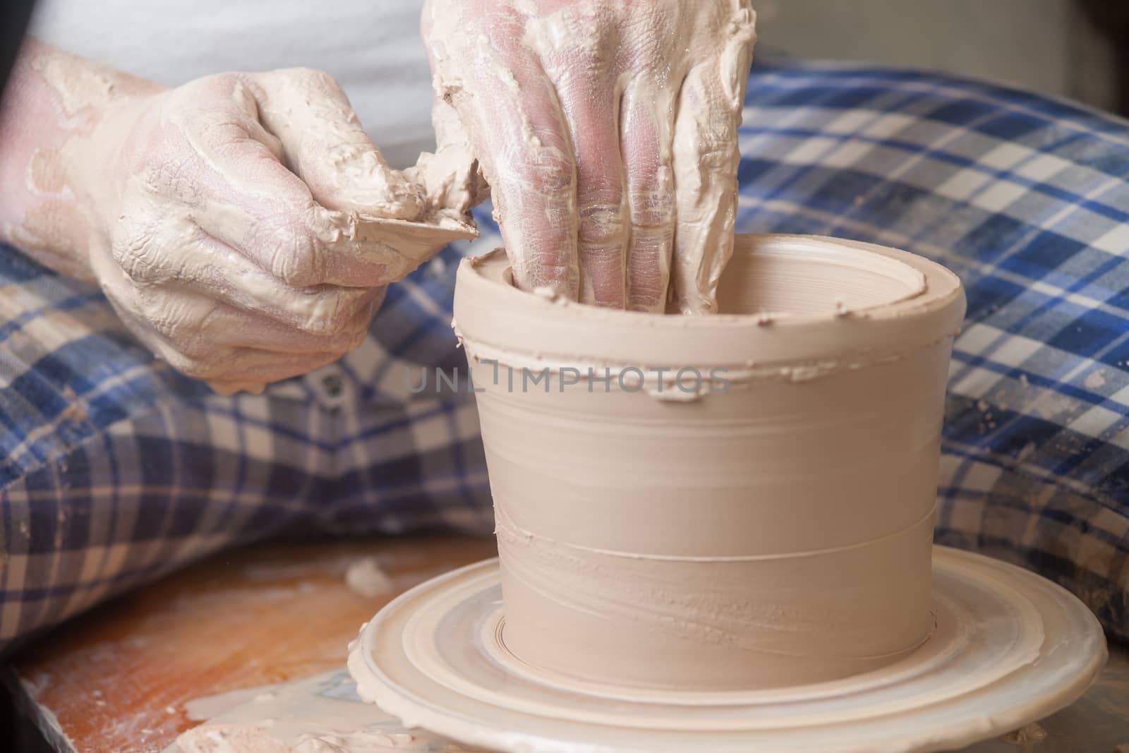 Hands of a potter, creating an earthen jar on the circle