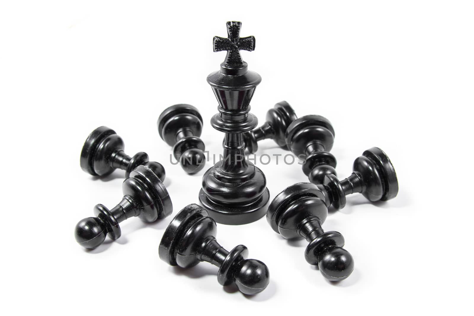 Chess king against chess pawns isolated on white background, small depth of field