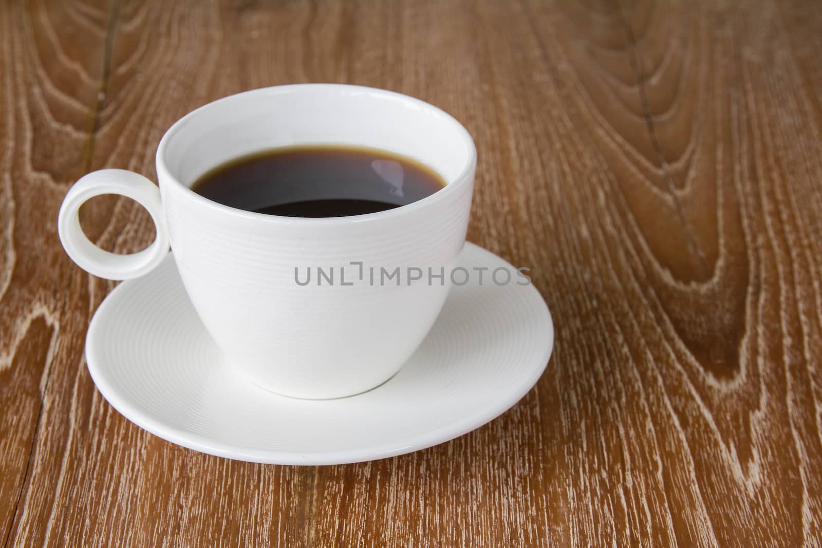 Cup of coffee on wooden table by kasinv