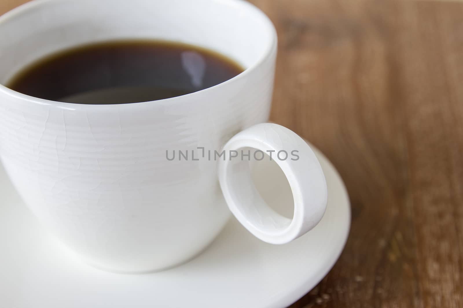 White cup of coffee on wooden table