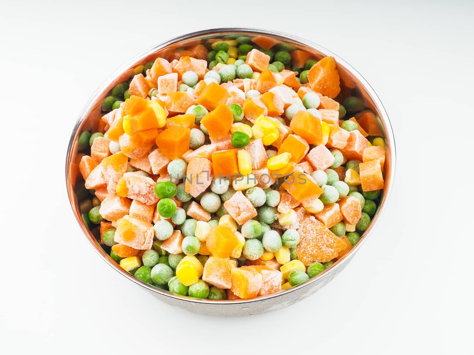 Frozen carrots, maize and peas, thawing in a steel bowl