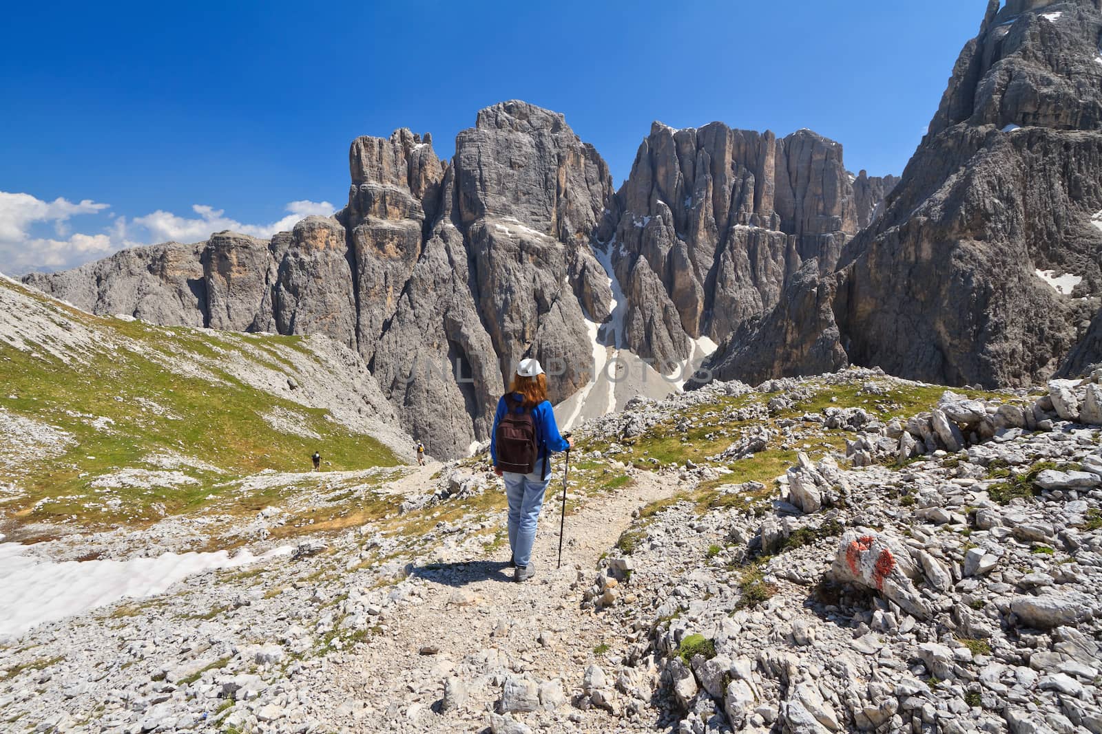 hiker on footpath  in Sella mountain, on background Mezdi valley and Piz da Lech peak, south Tyrol, Italy