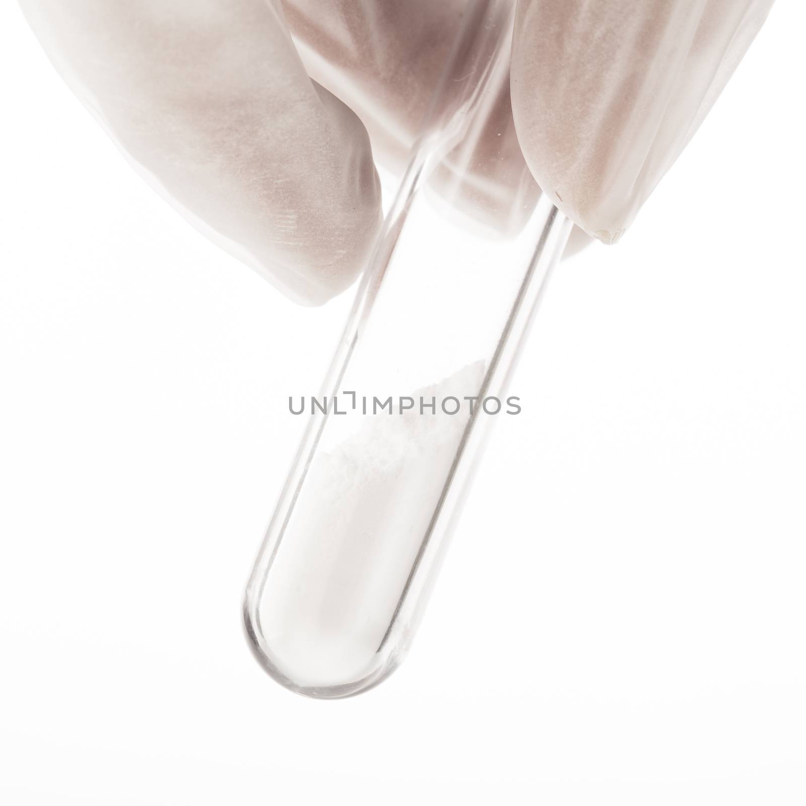 Close up of white powder in test tube being held by fingers