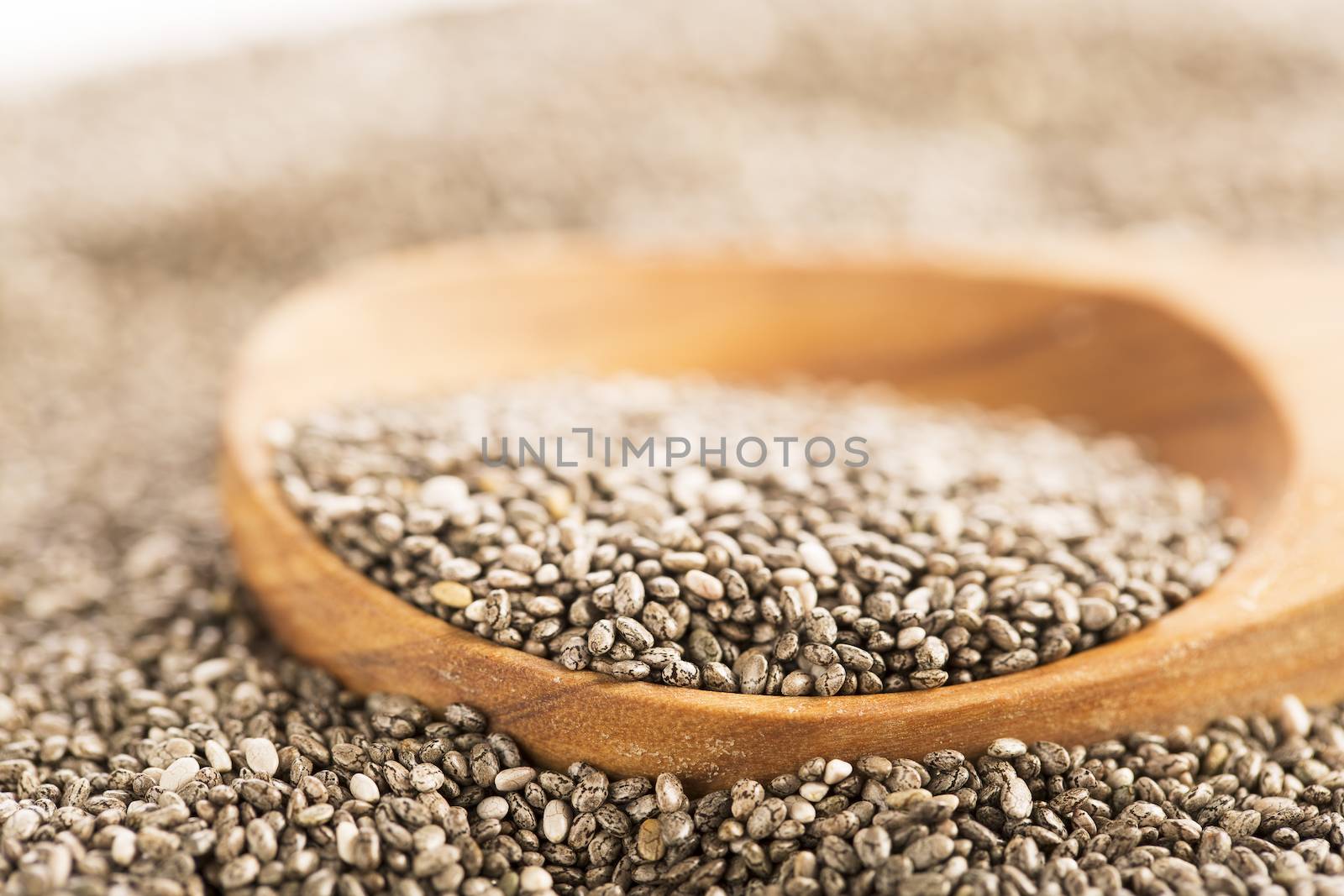 Dark Chia seeds on wooden spoon.  Heart healthy source of omega-3s
