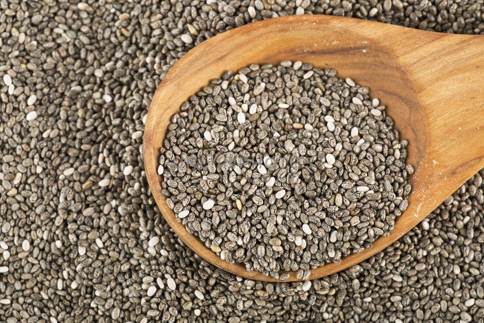 Dark Chia seeds on wooden spoon.  Heart healthy source of omega-3s
