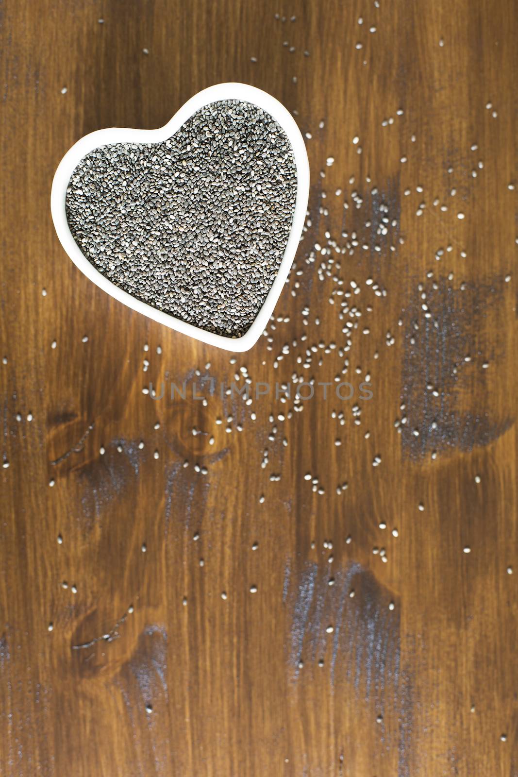 Healthy dark chia seeds in heart container