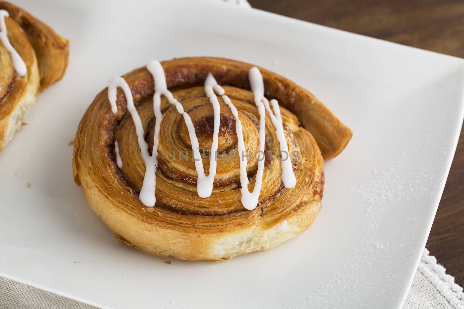 Tempting Cinnamon roll on white plate.