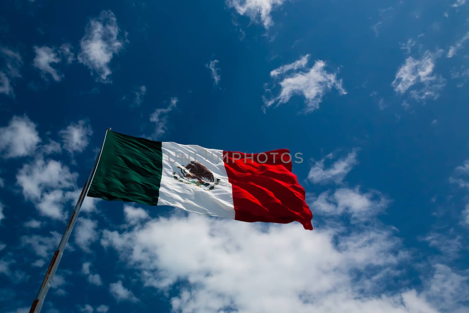 The Flag of Mexico seen from below on a rich blue sky