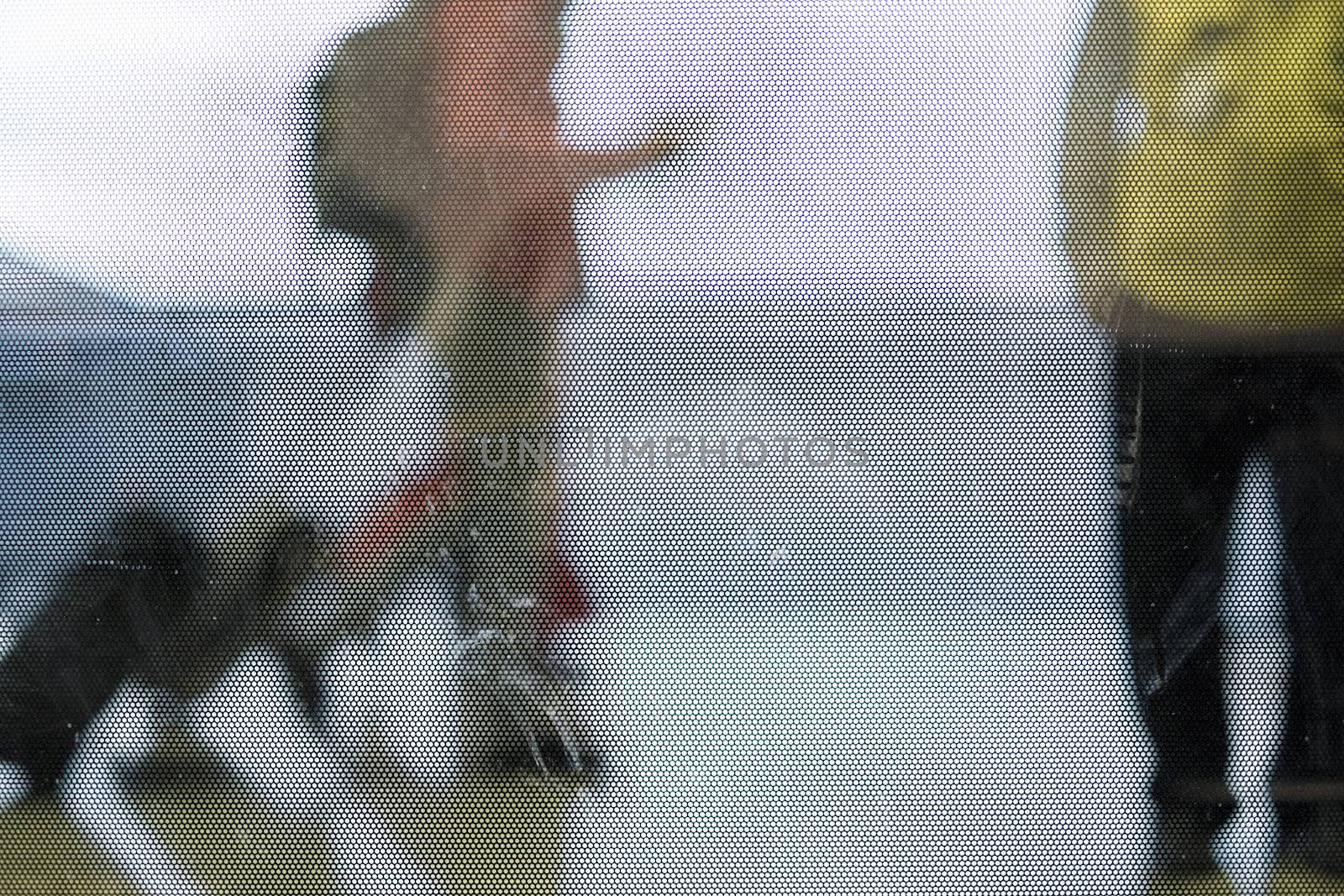 Cropped out of focus shot of passengers caring luggages in airport corridor