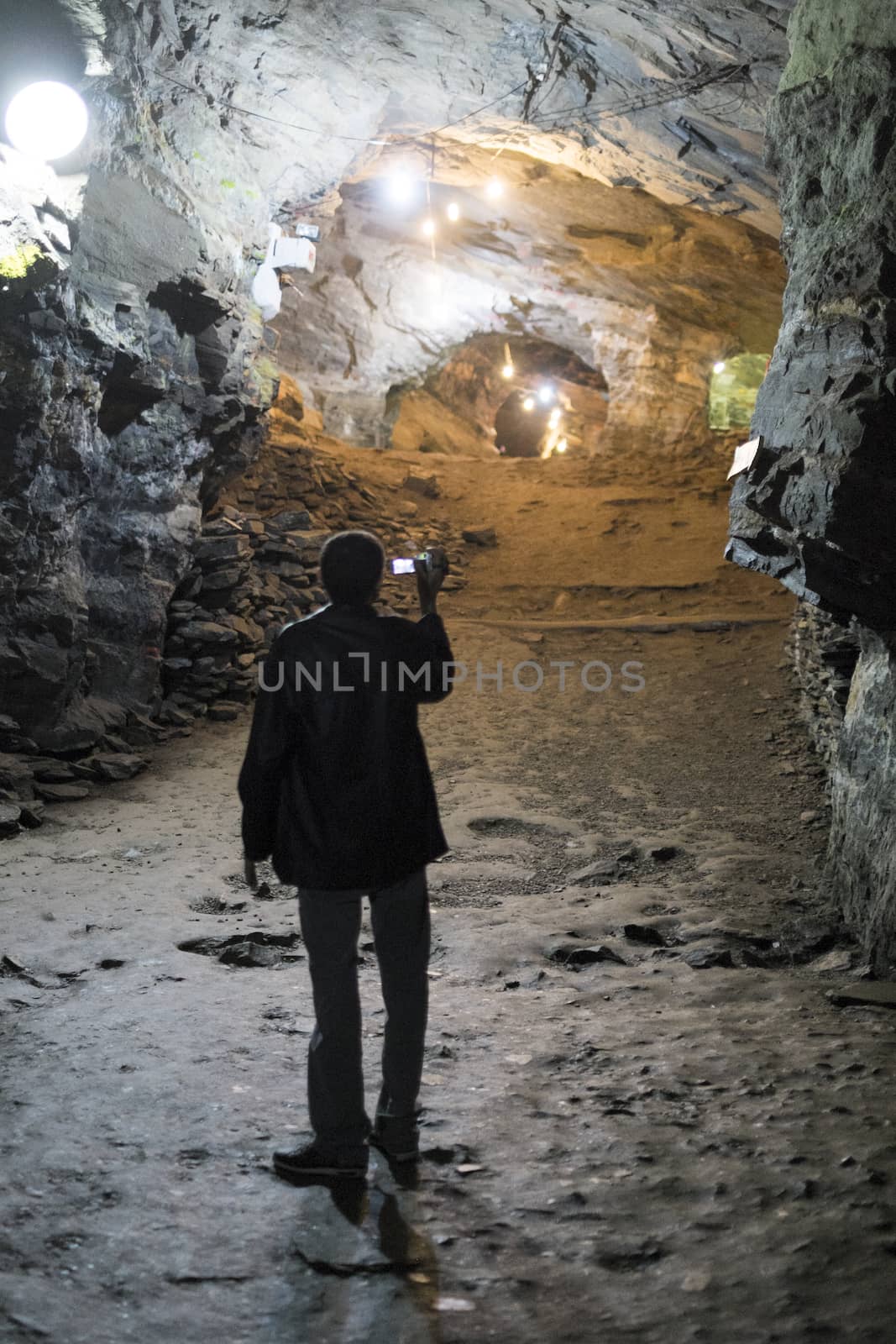 OURO PRETO, BRAZIL - JULY 27: Tourist filming the Passage Mines tunnels. Connecting two cities it is the largest disused gold mine open to visitation in the world. July 27, 2014 in Ouro Preto.
