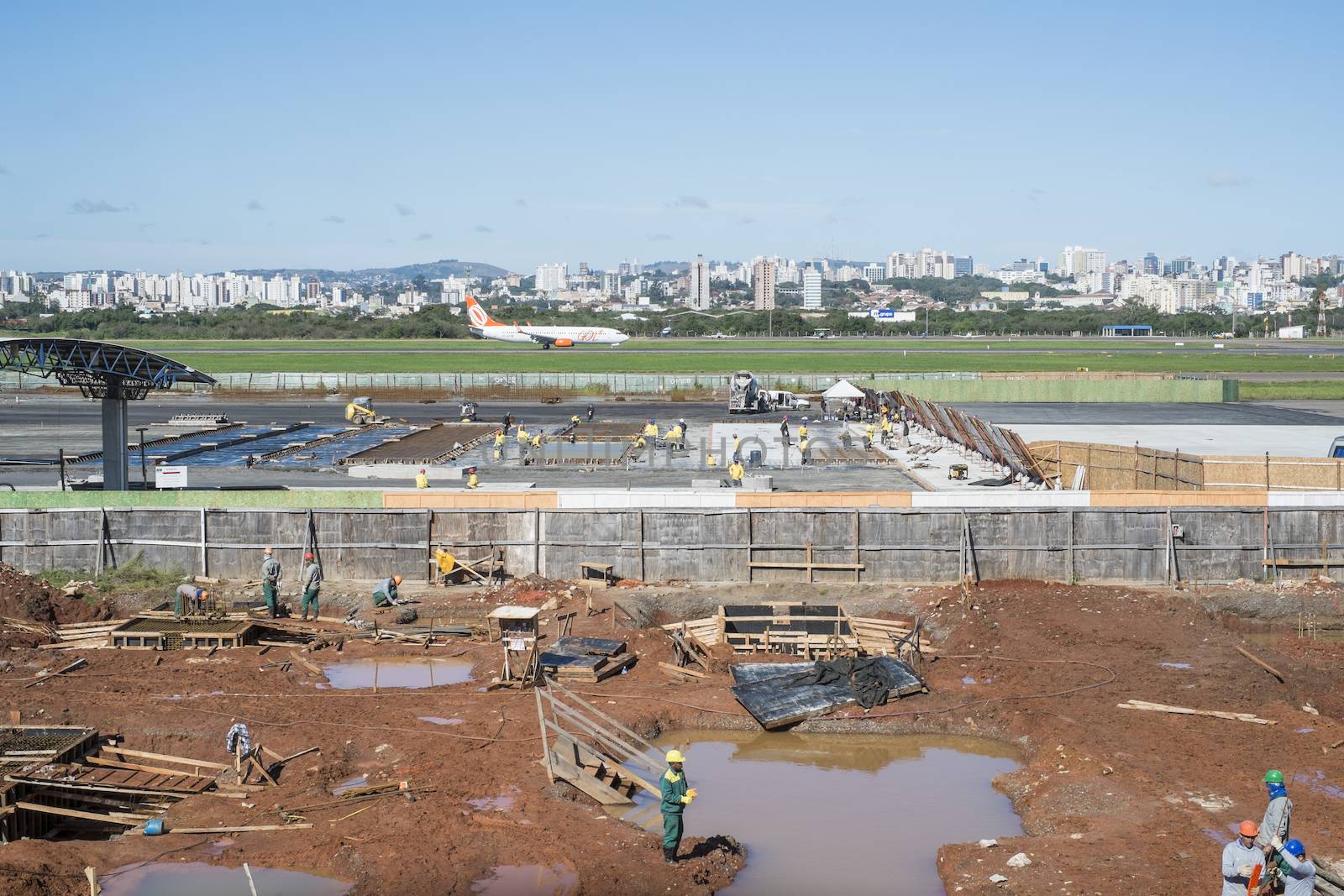 PORTO ALEGRE, BRAZIL - JULY 25: A Brazilian airplane lands next to Salgado Filho's airport expansion works. The expansion was intended to be finished in May for the World Cup, but a series of industrial actions set the new completion forecast to 2016. July 25, 2014 in Porto Alegre, Brazil.