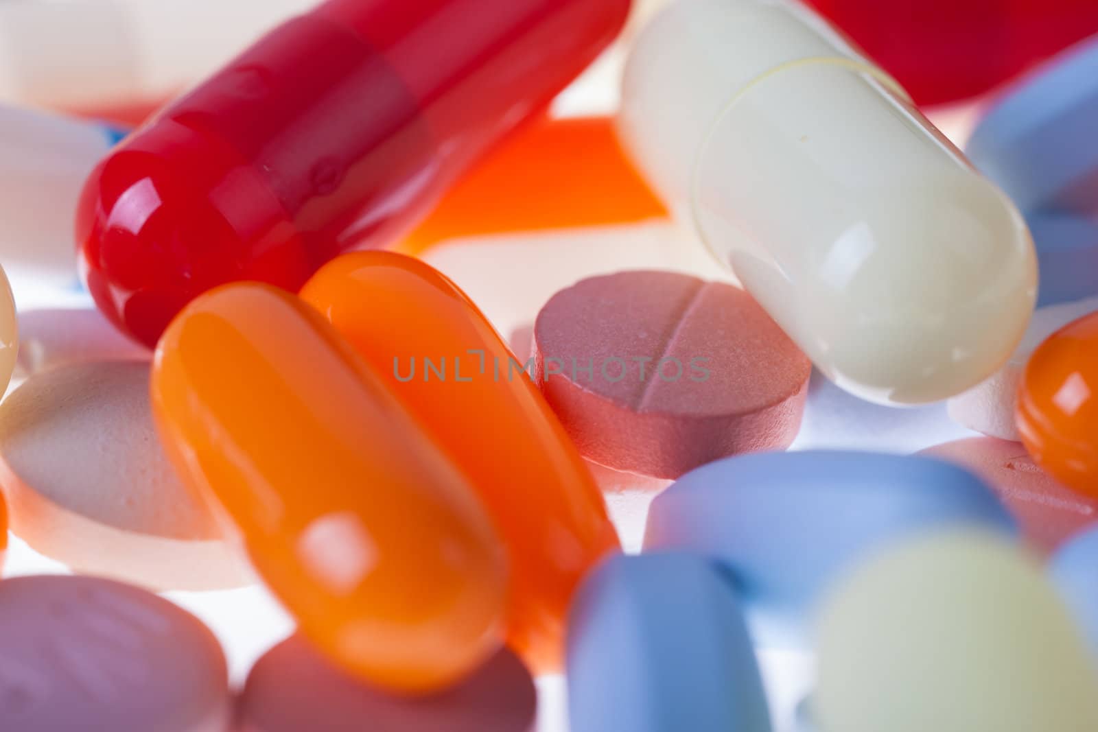 A lot of colored pills and tablets over a white background