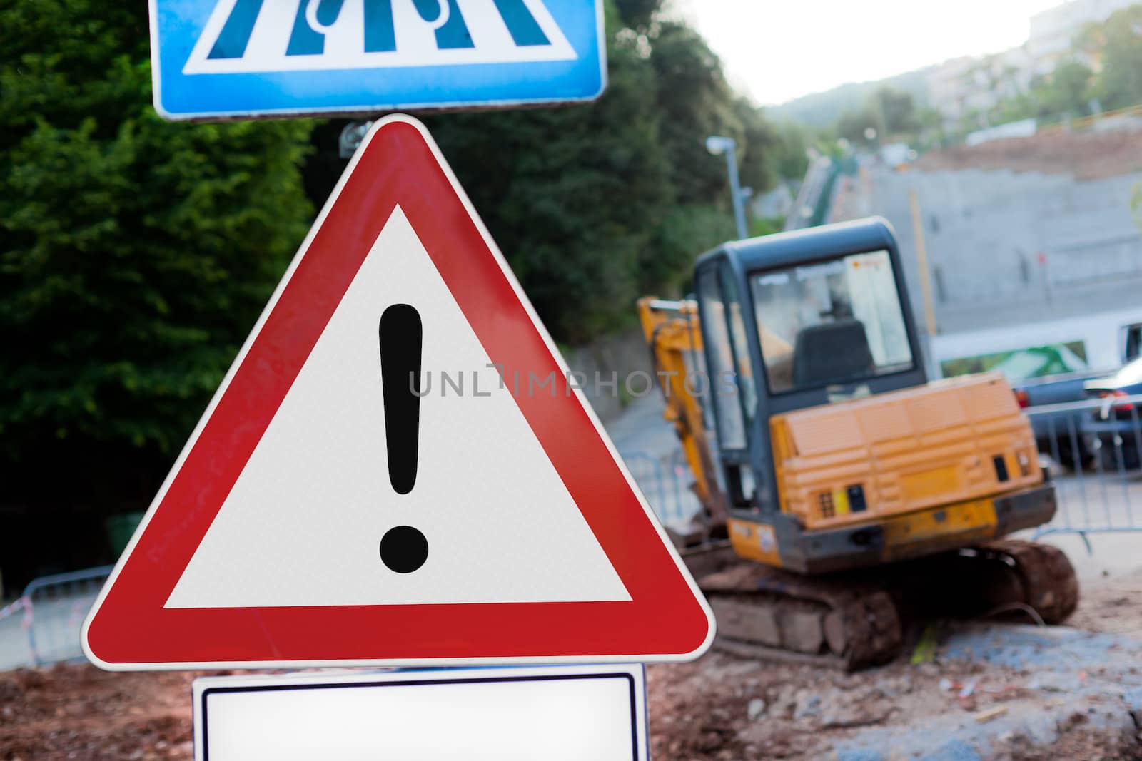 Warning Sign and a blurred excavator in background