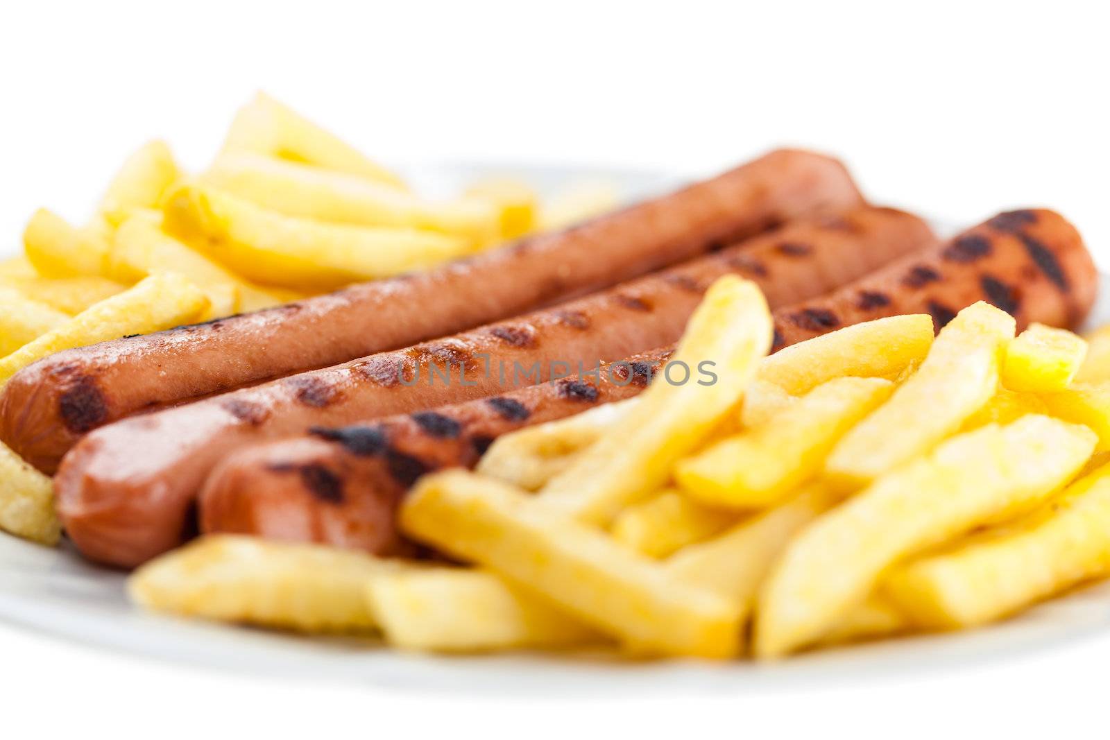 three delicious wurstel on a white plate with french fries