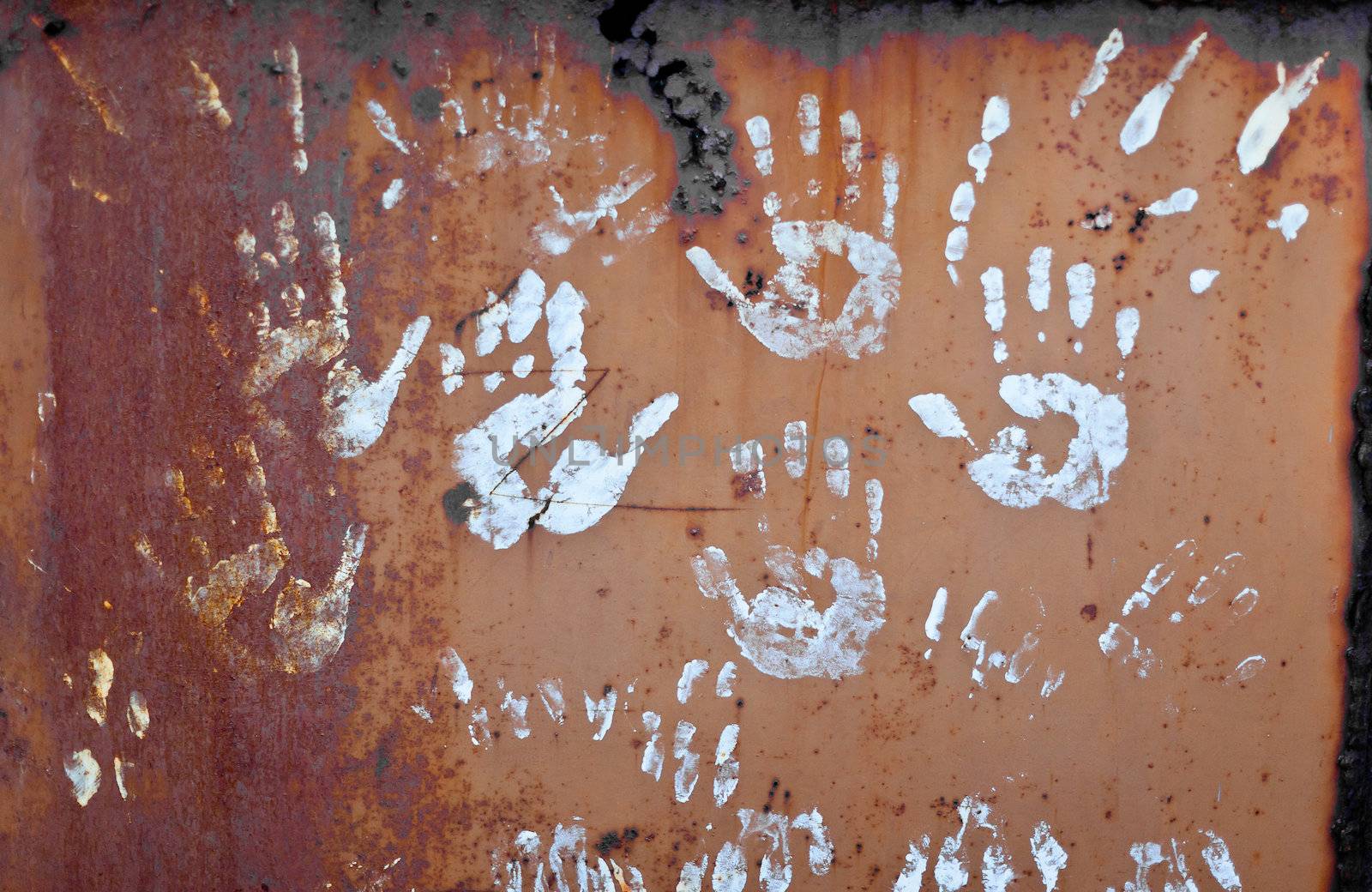 some white handprints on a rusty surface
