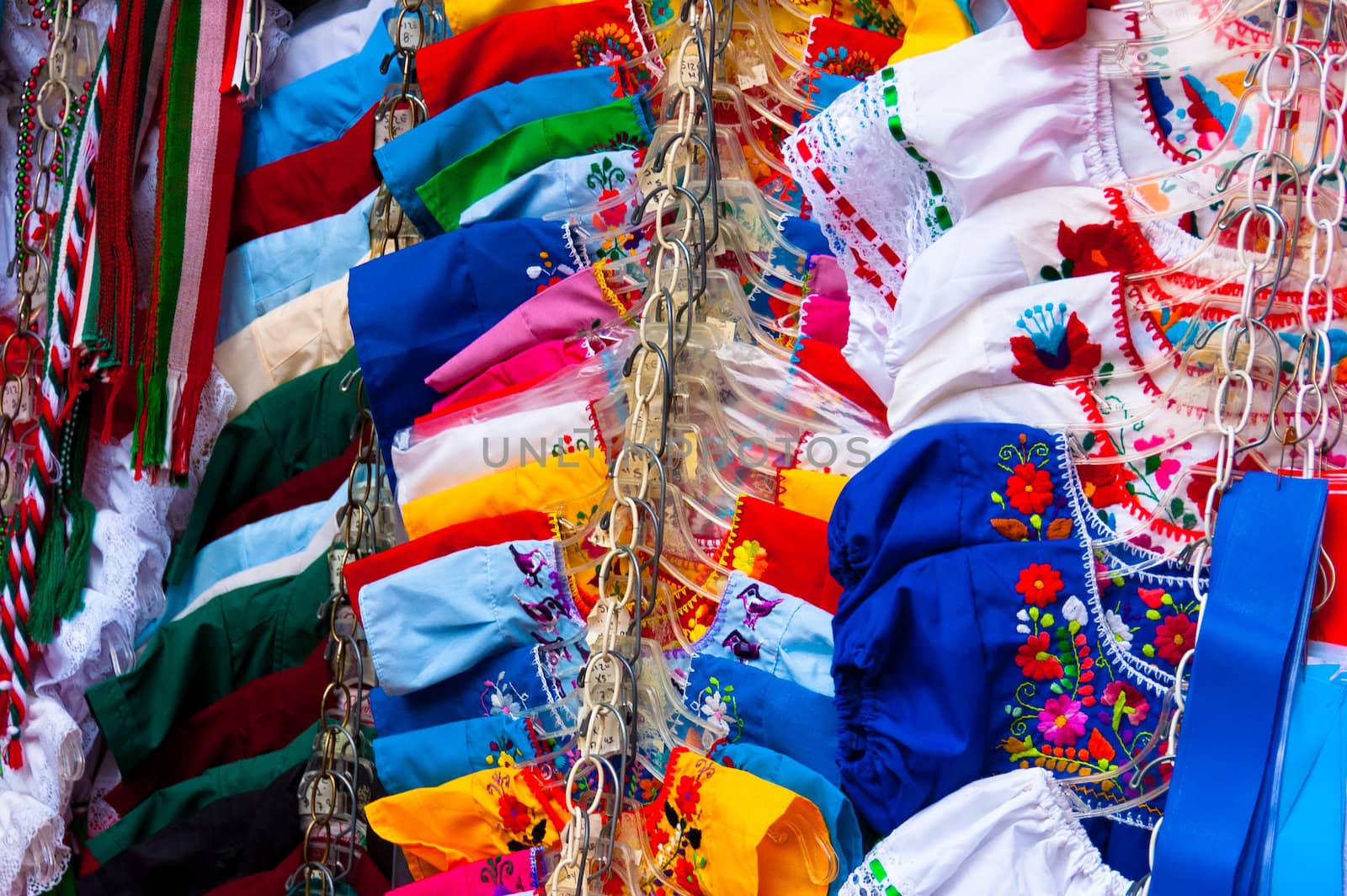 a lot of mexican traditional dresses in a little shop