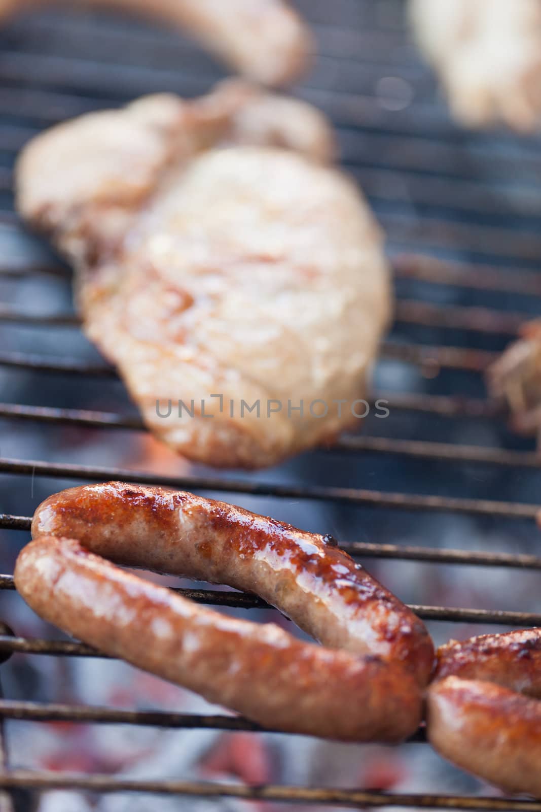 Several type of meats being cooked on a barbecue