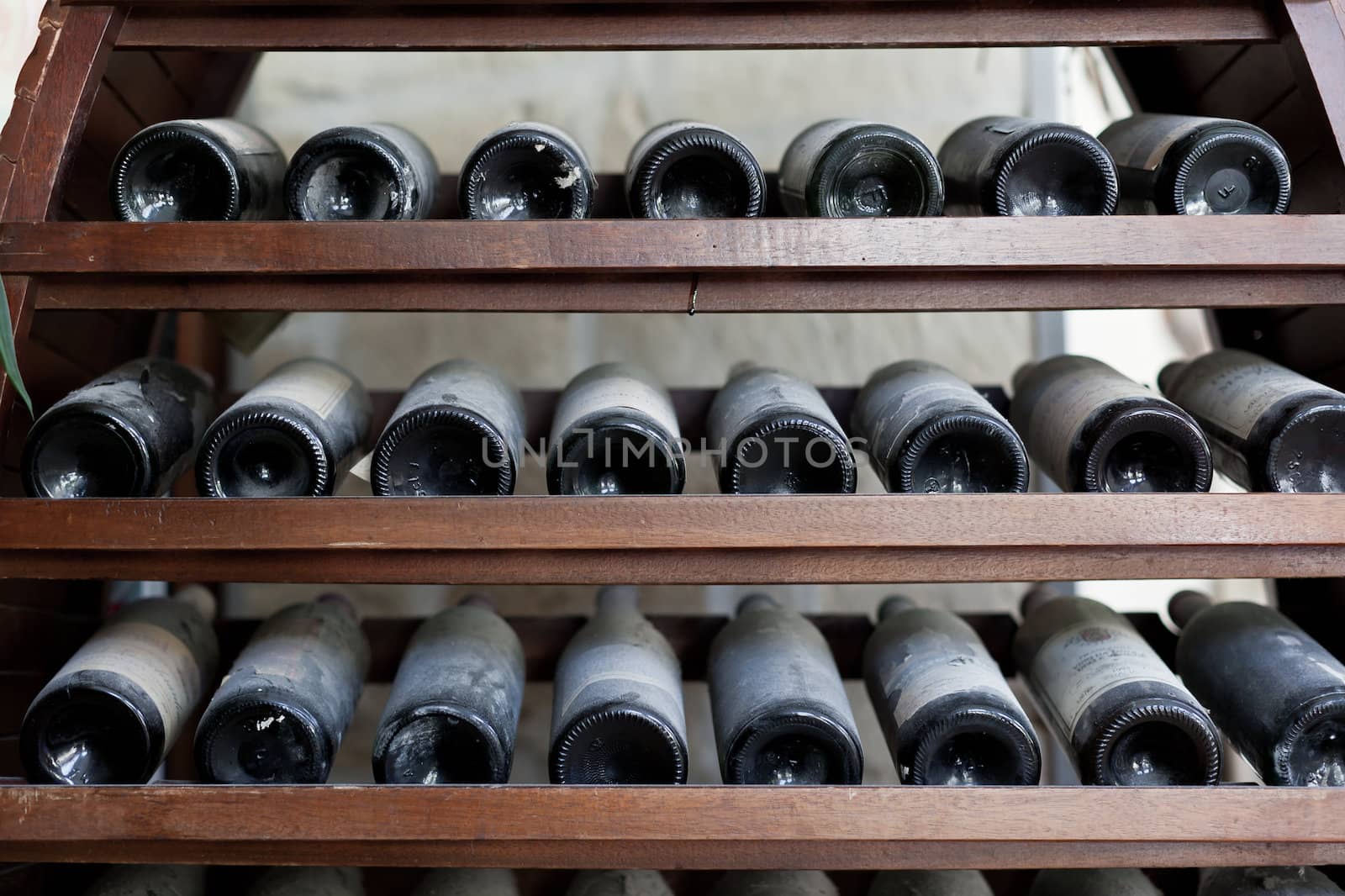 some very old and dusty wine bottles in a wine cellar