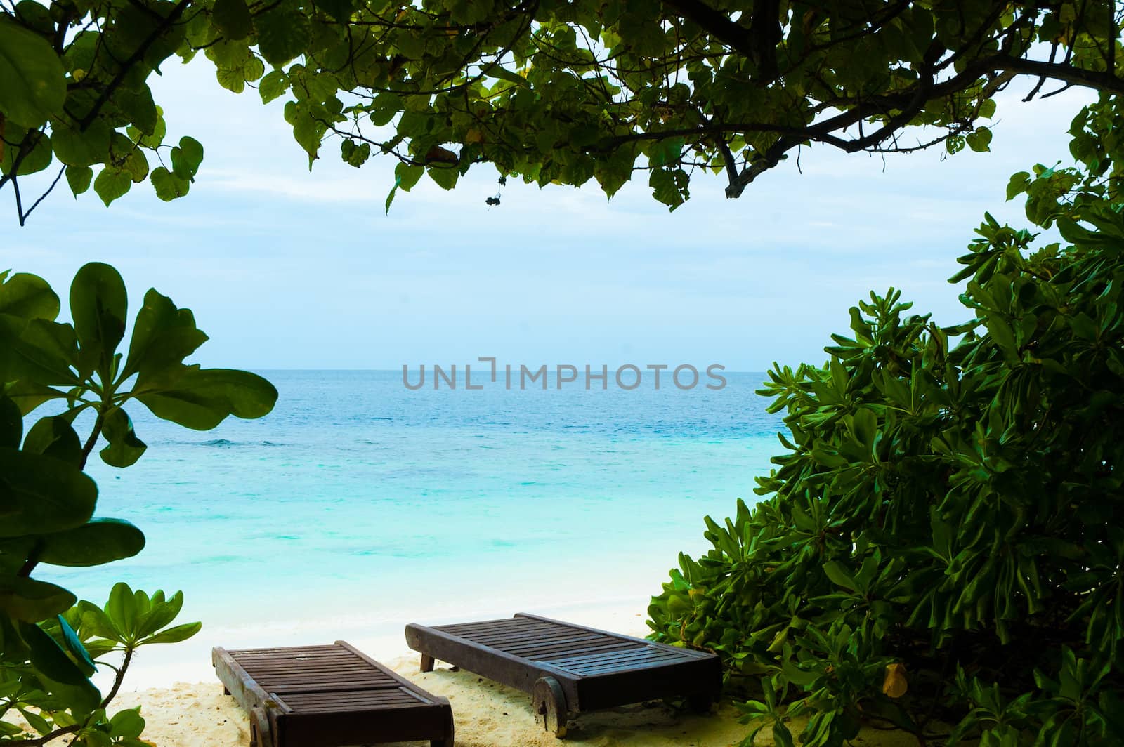 Tropical beach with wooden chairs
