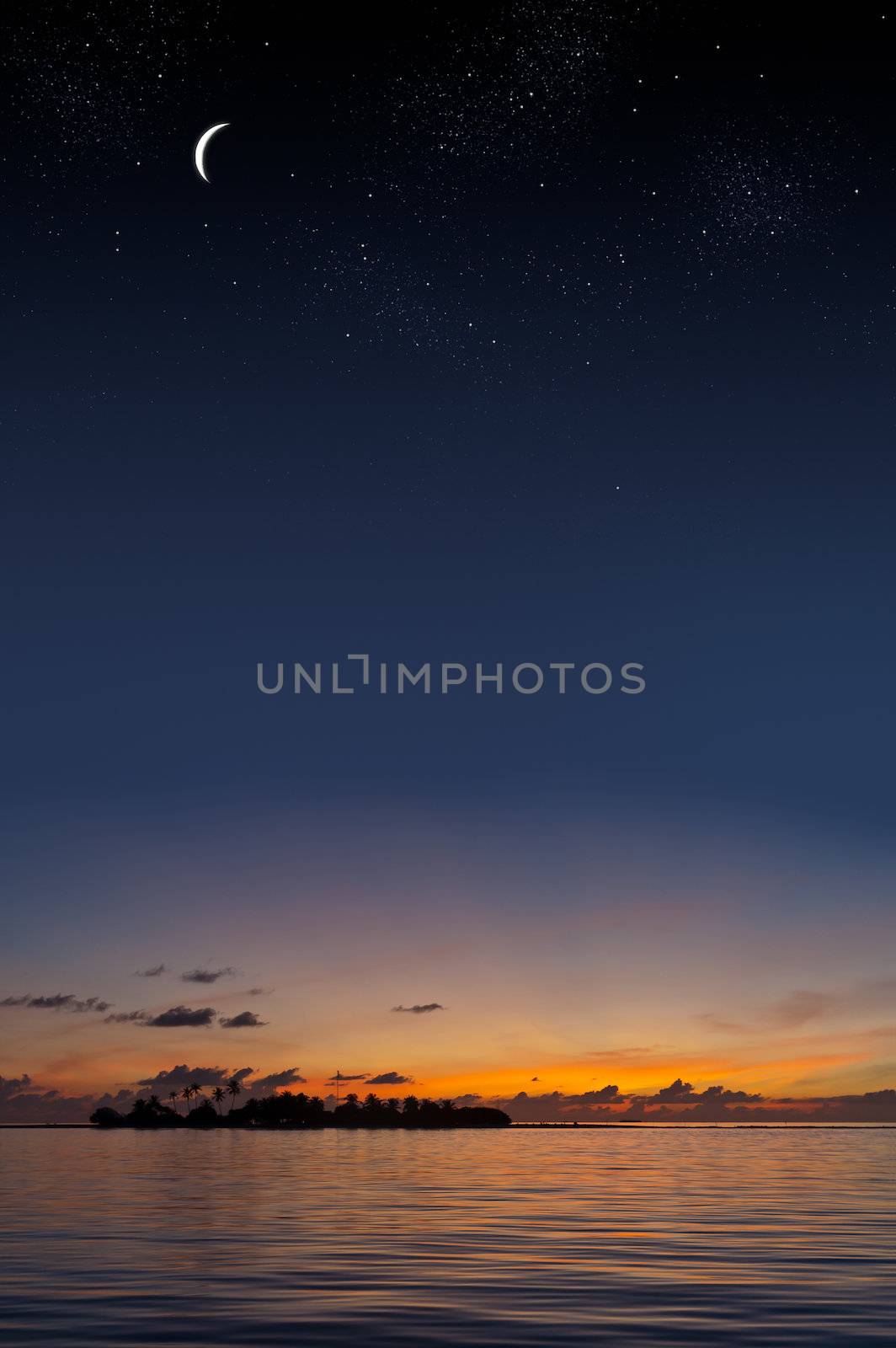 Tropical sunset with an island shilouette under a starry sky