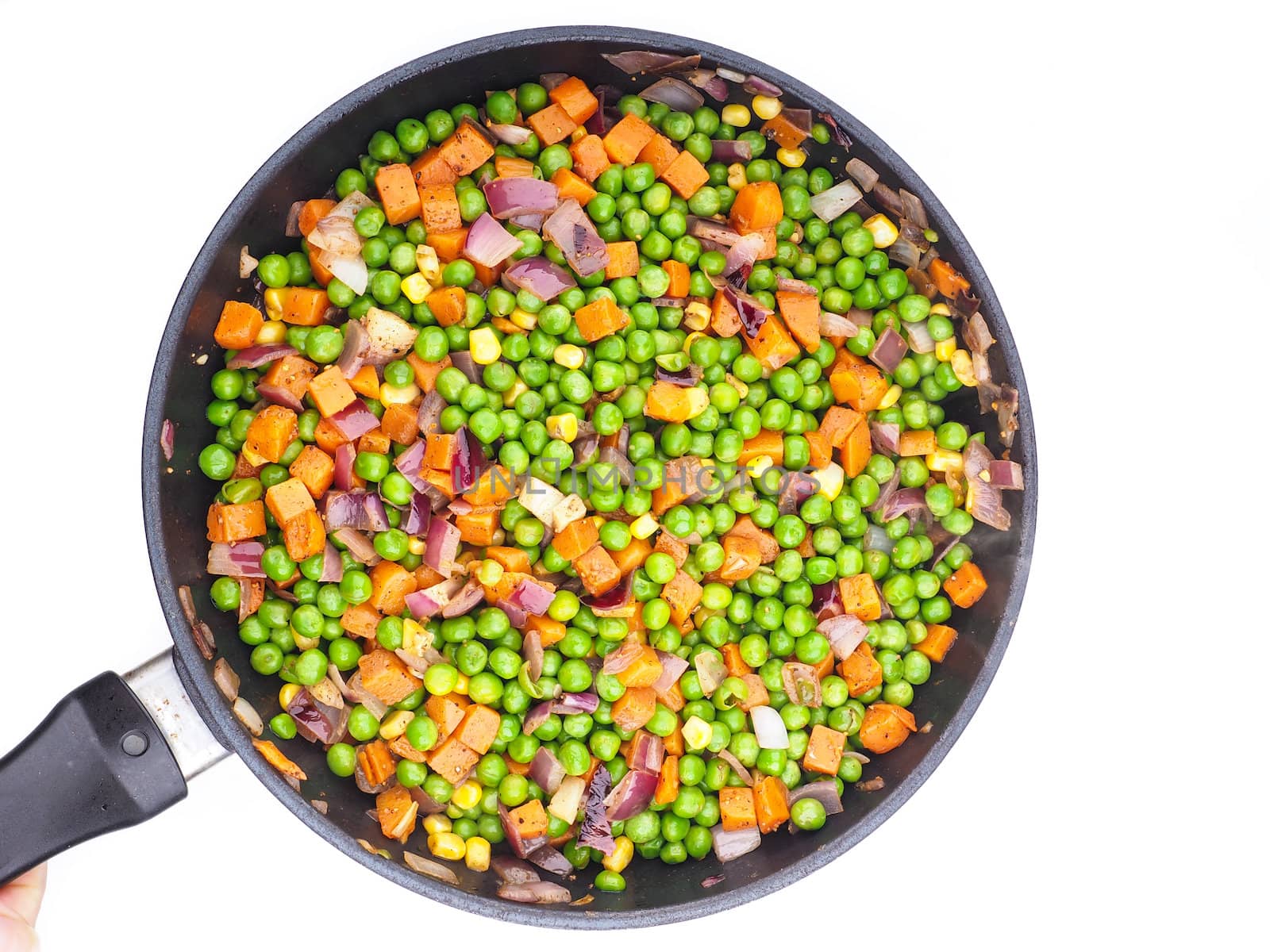 Fry pan isolated towards white background with peas, corn and red onion