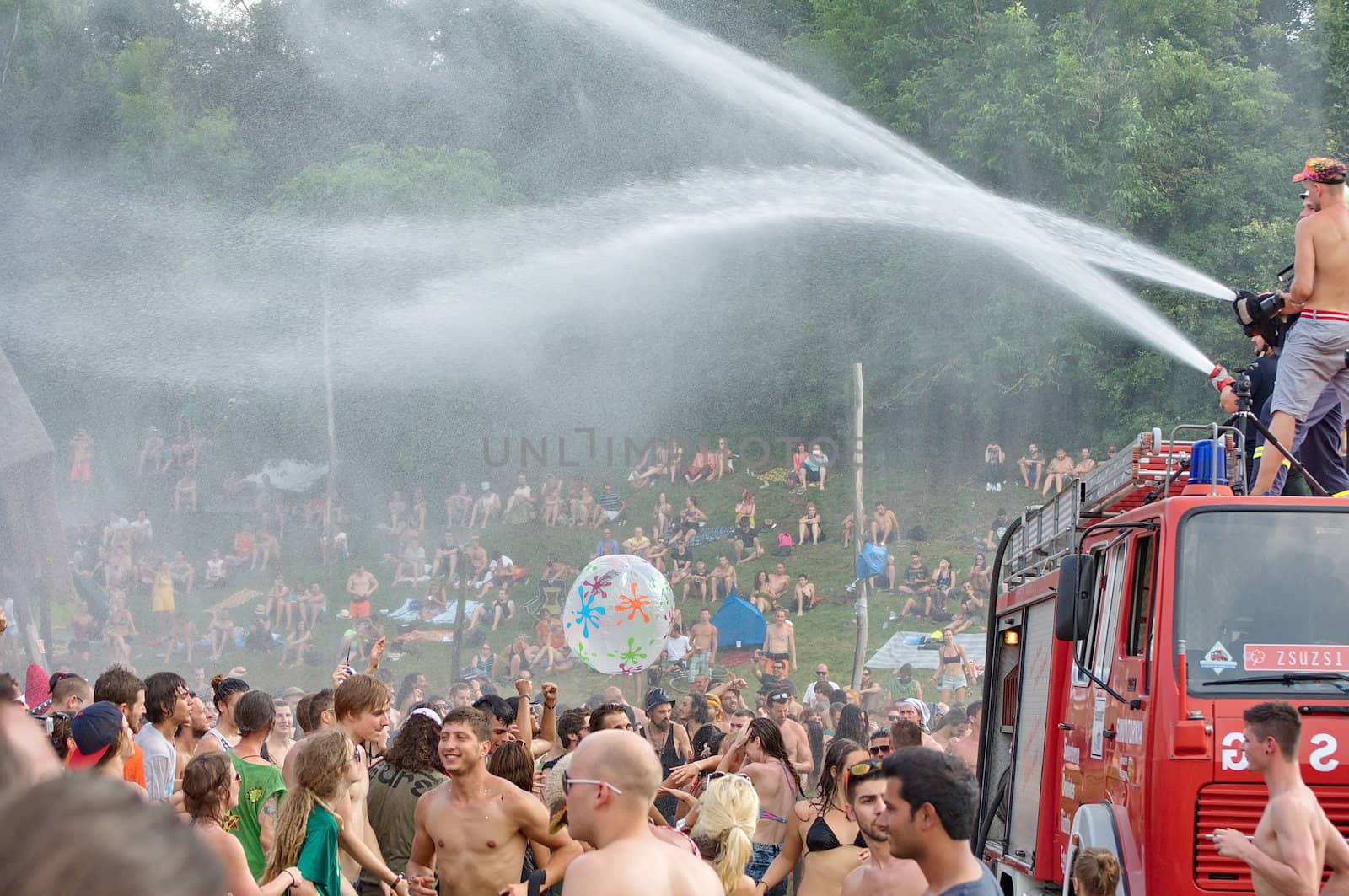 OZORA, HUNGARY - AUGUST 01: Fire department spray water on crowd on Ozora Festival, one of the greatest psychedelic music gathering in Euorpe. Ozora, Hungary, Europe August 01, 2014.