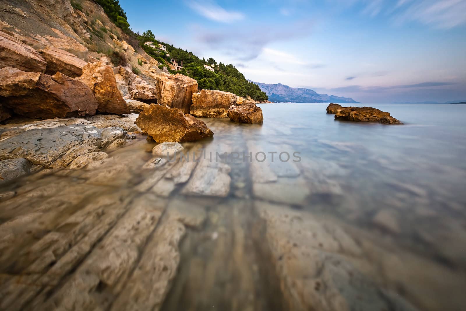Rocky Beach and Transparent Adriatic Sea near Omis in the Evenin by anshar
