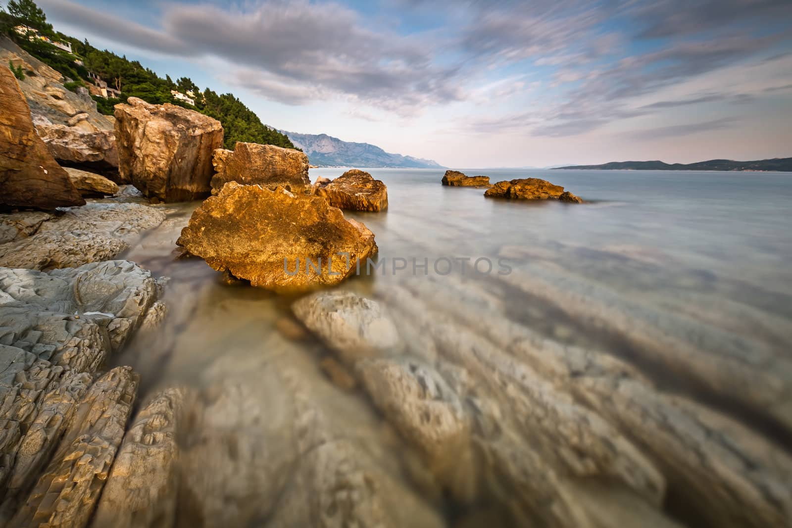 Rocky Beach and Transparent Adriatic Sea near Omis in the Evenin by anshar