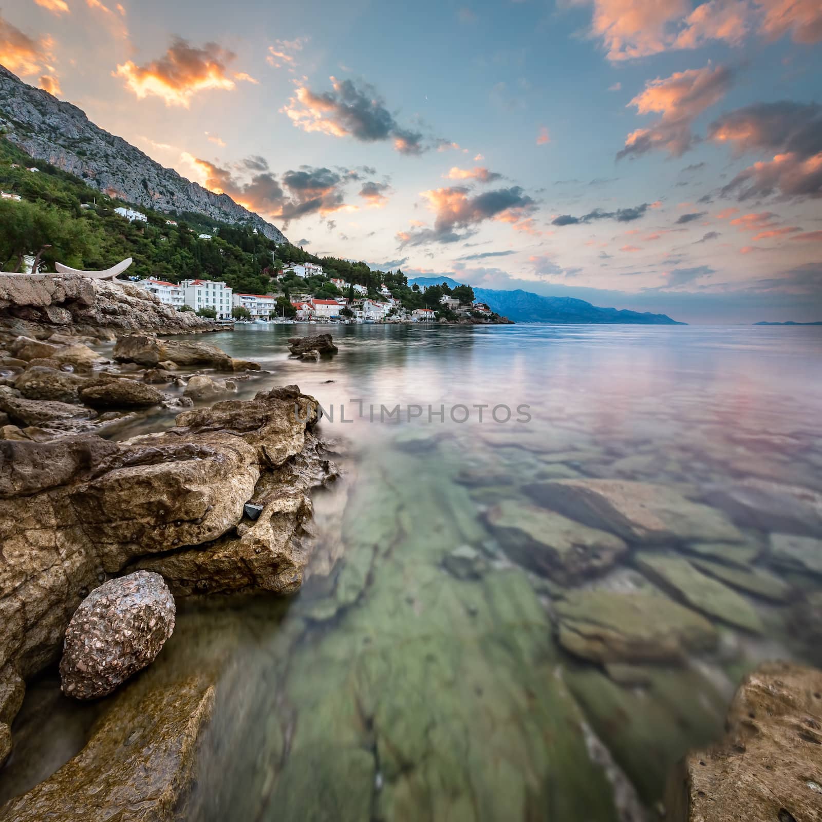 Sunrise on Rocky Beach and Small Village near Omis, Dalmatia, Cr by anshar