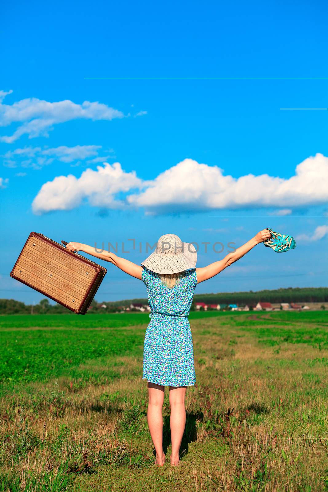 Woman in summer dress with a suitcase by Nobilior