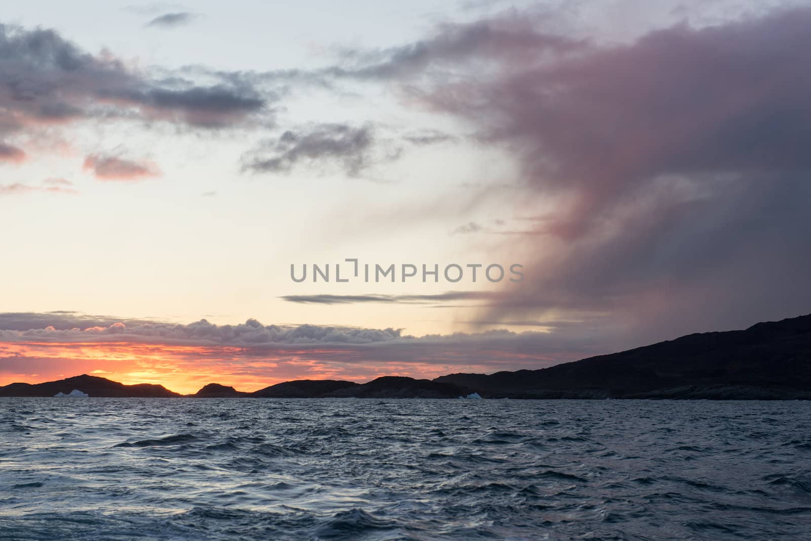 Sunset at arctic coast with cloudscape on Disko Island in Greenland